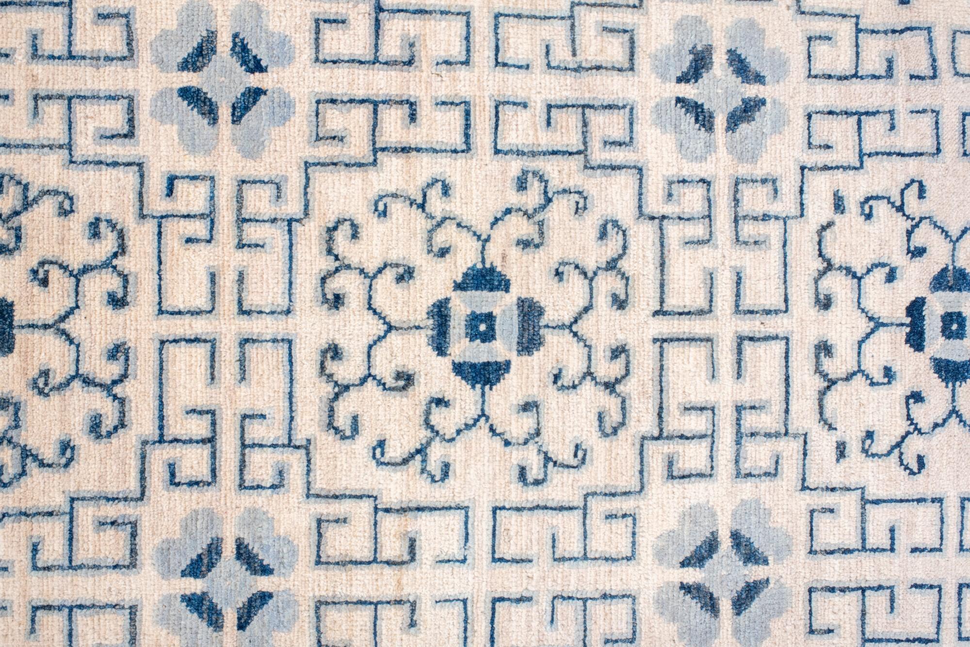 Annodato a mano Tappeto Khotan con disegni a melograno e a reticolo ripetuti in blu e avorio. in vendita