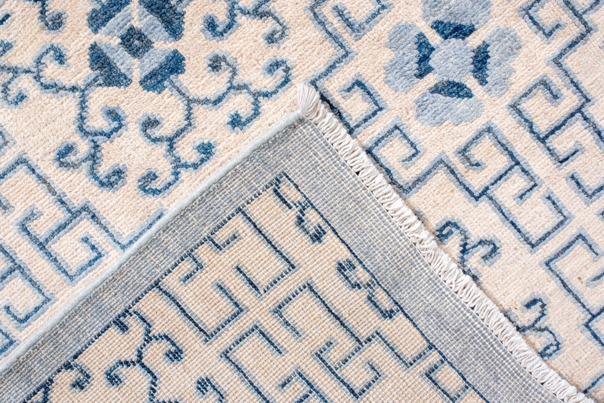 XX secolo Tappeto Khotan con disegni a melograno e a reticolo ripetuti in blu e avorio. in vendita