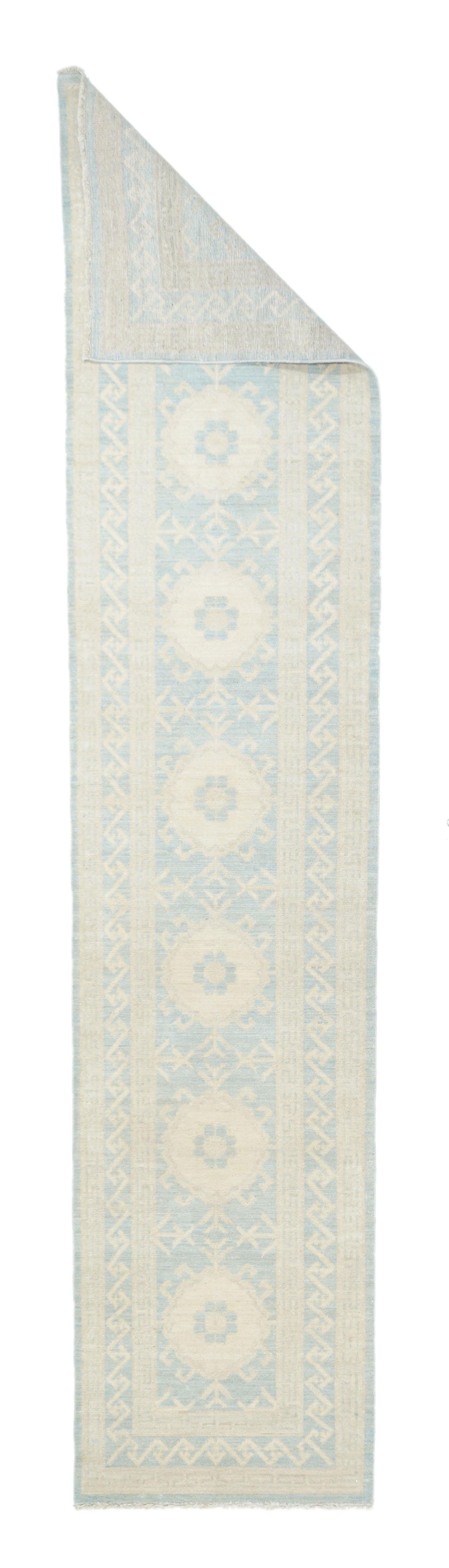 Alfombra Khotan 2'1'' x 10'0''. Este kenare (corredor) del Turkestán Oriental muestra un campo y un borde azul claro con siete medallones y un dibujo S/Z entrelazado, respectivamente. Paleta de luz. Estado como nuevo en una urdimbre de algodón con