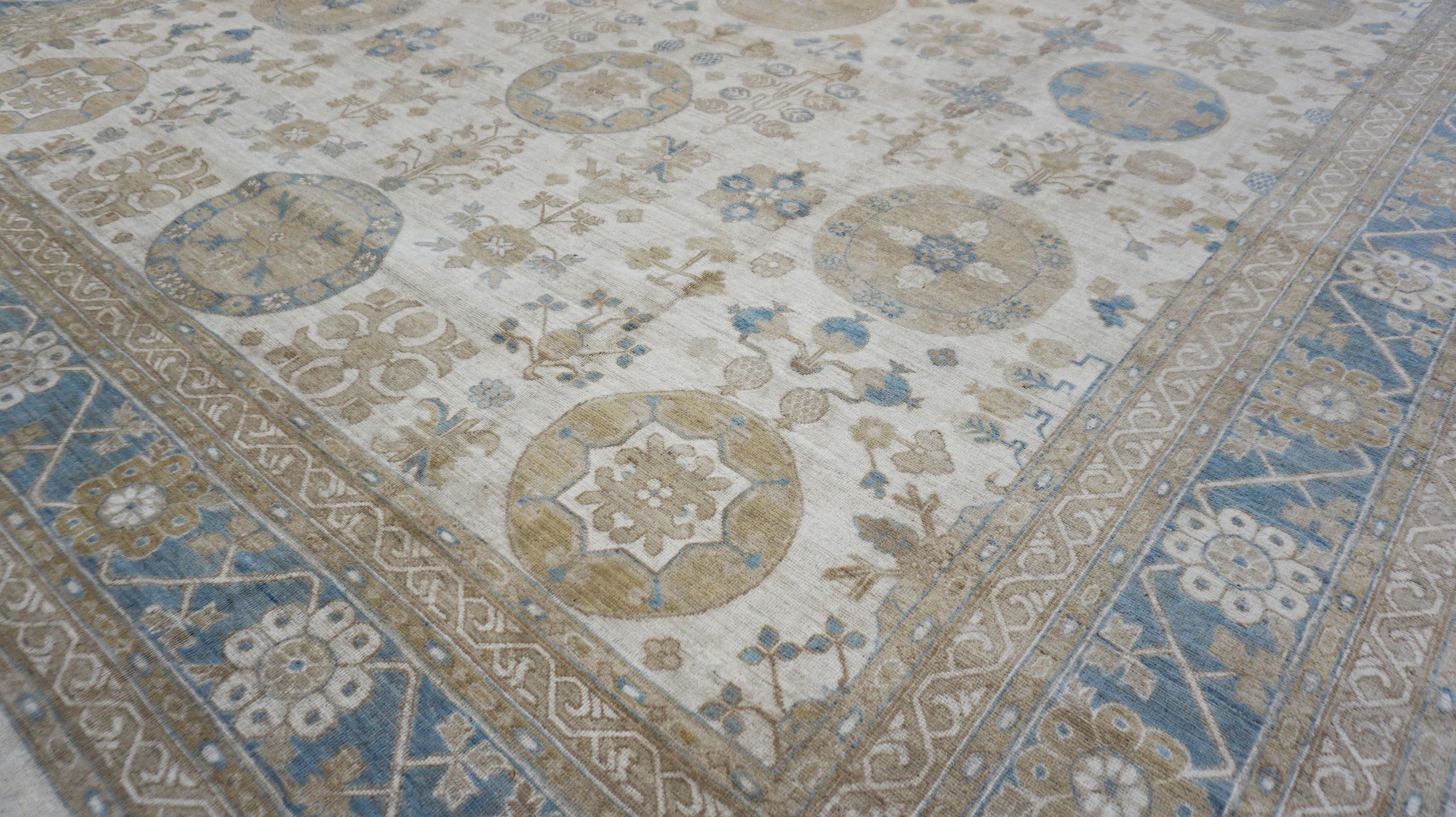 This elegant hand-knotted Khotan Pattern wool rug showcases a harmonious blend of traditional craftsmanship and refined design, making it a timeless addition to any sophisticated interior. Featuring a classic  pattern, the rug is adorned with large
