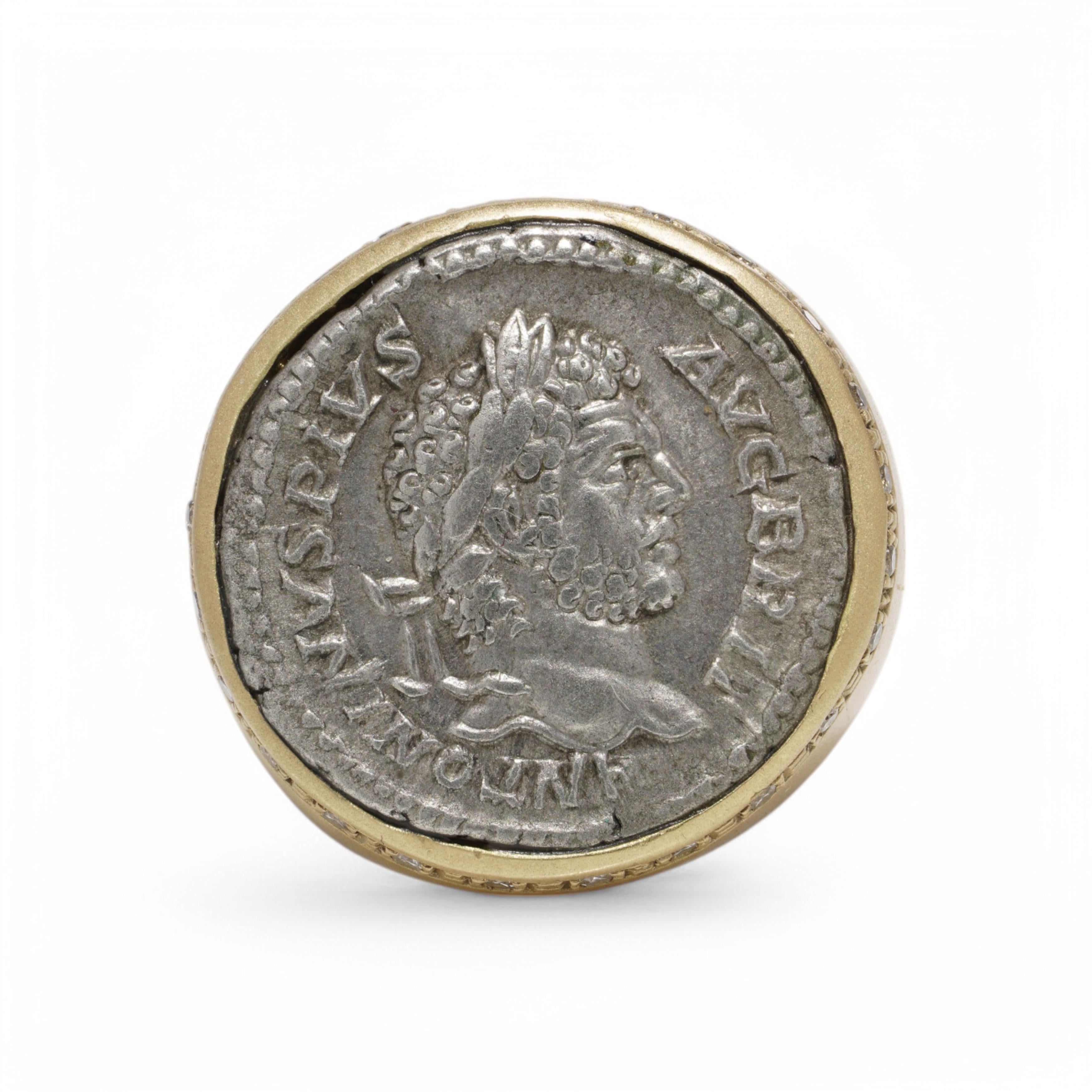 A distinguished 18kt yellow gold signet ring featuring an authentic Ancient Roman silver denarius depicting Emperor Antoninus Pius (reigned AD 138–161). The bezel is intricately set with this historical coin, showing the emperor’s laureate profile,
