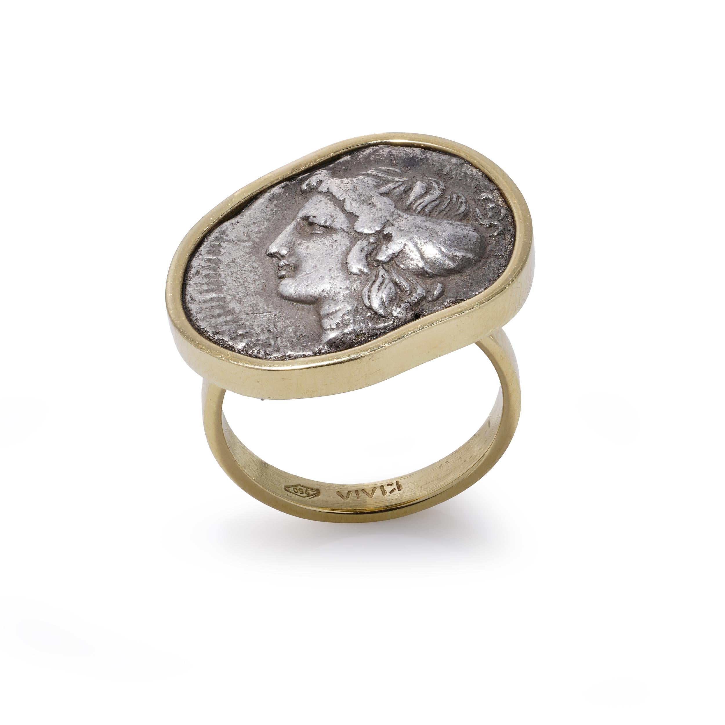 Ancient Greek Tetradrachm Coin Ring, 18K Gold Mount.

A striking ancient Greek silver tetradrachm, likely issued under Lysimachus (circa 305–281 BC), mounted in an 18K yellow gold ring. The obverse features a portrait of Alexander the Great.
Crafted