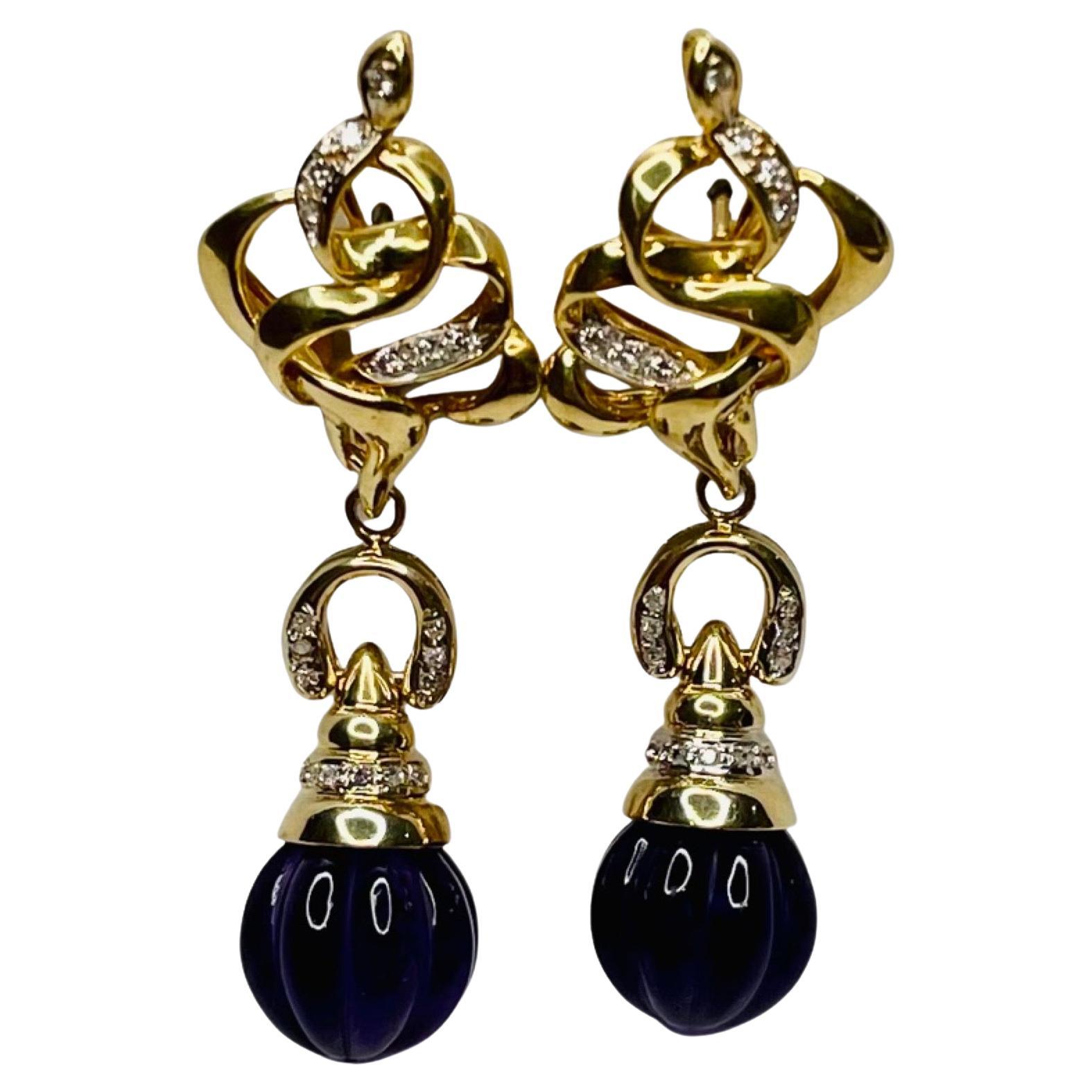 Kian 14K & 18K Yellow Gold Amethyst and Diamond Earrings. There are 2-11.5 mm carved amethyst balls with 14KY gold caps. There are 5 single cut diamonds, bead set on each cap and 6 on each upside down U-shape above the ball. There are 22 single cut