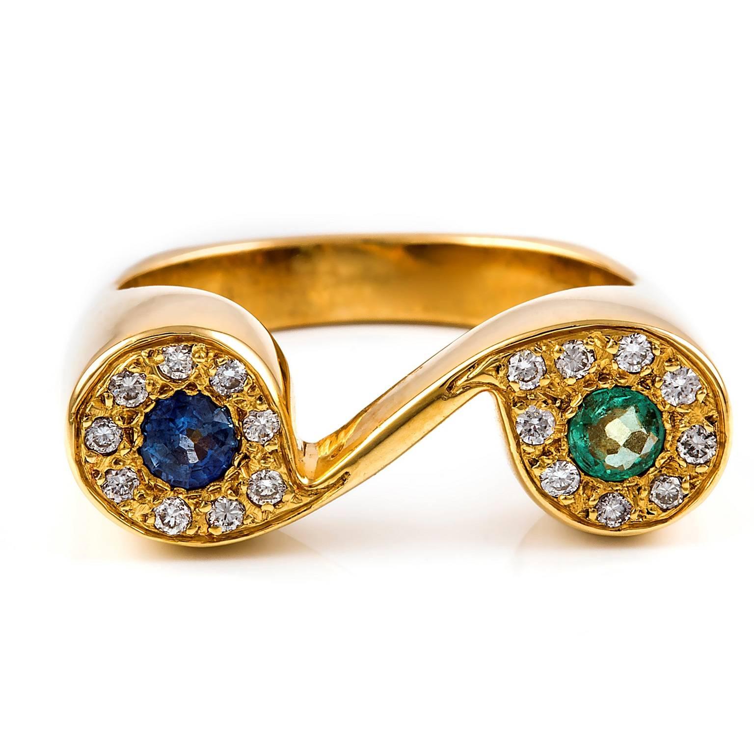 Two lovely stones, an emerald and a sapphire, are featured at the centres of the diamond settings that form this unique scroll style ring.

Round faceted emerald: light green colour, lively stone, 3.30mm

Round faceted sapphire: medium blue colour,