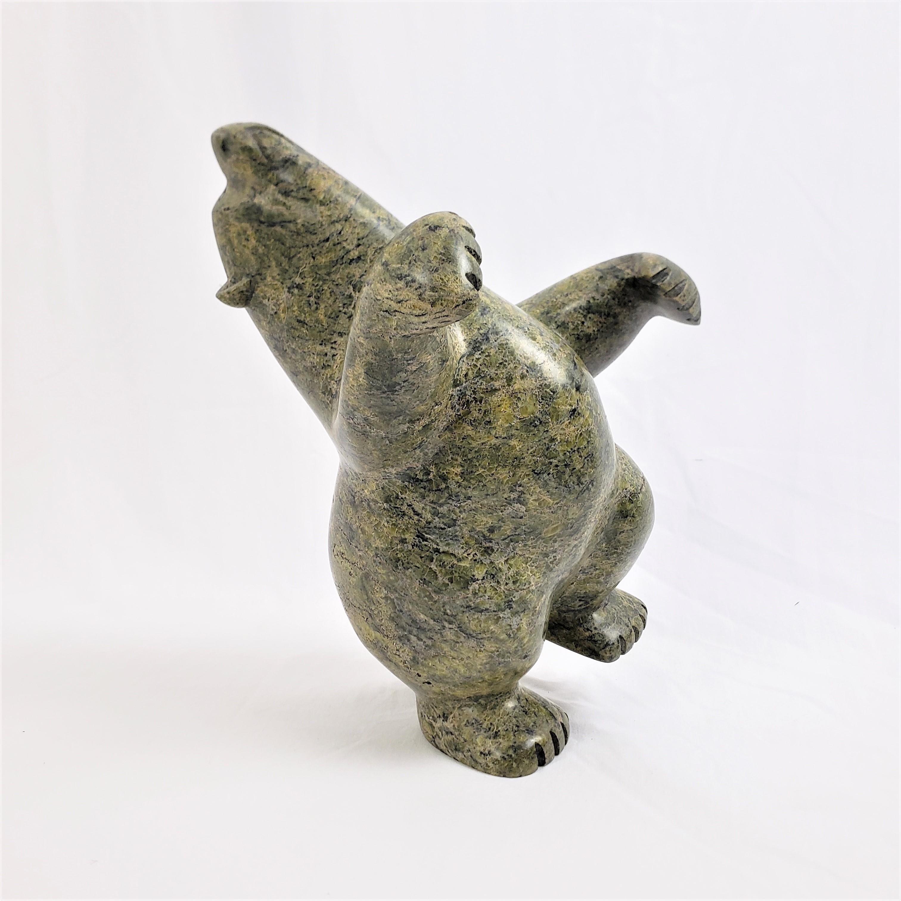 This sculpture was done by the wel known Kiawak Ashoona of Canada in approximately 1970 in the period Inuit style. The sculpture is composed of a green soapstone with gold and black striations and depicts a standing or dancing bear. The sculpture is