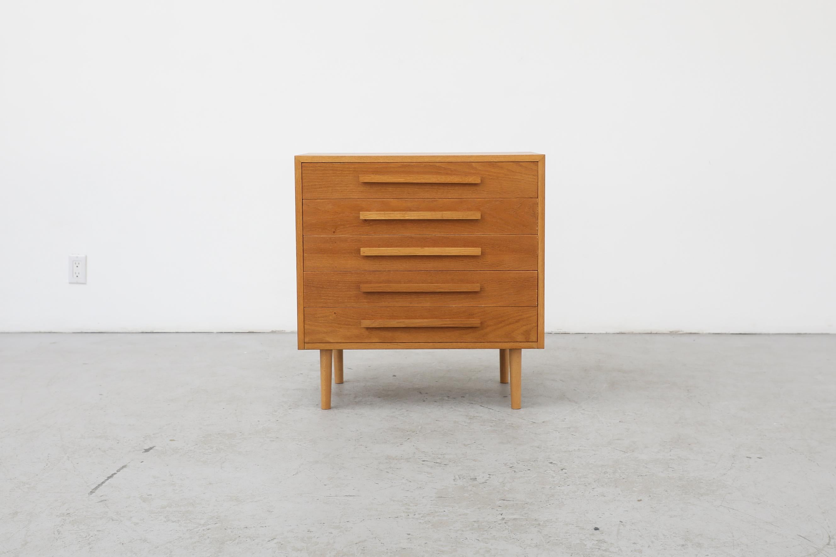 Mid-Century oak 5 drawer dresser in the style of Kibaek Roefen, with long carved linear pulls and tapered legs. In original condition with visible wear and patina consistent with its age and use.