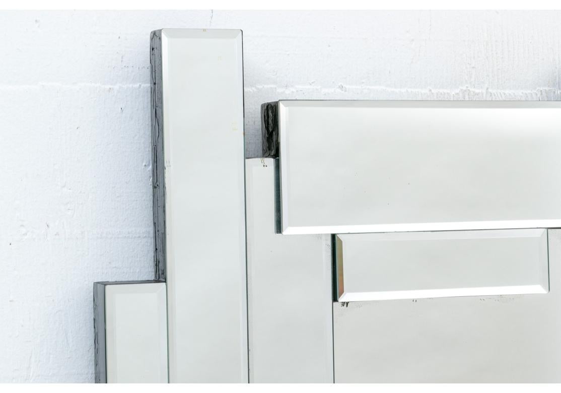 A very sculptural 70's style design with 3-D pieced beveled mirror sections overlapping in an irregular fashion. The Mirror is out of production. 
This modern-styled mirror features a beveled rectangle mirror pieces that form a geometric work that