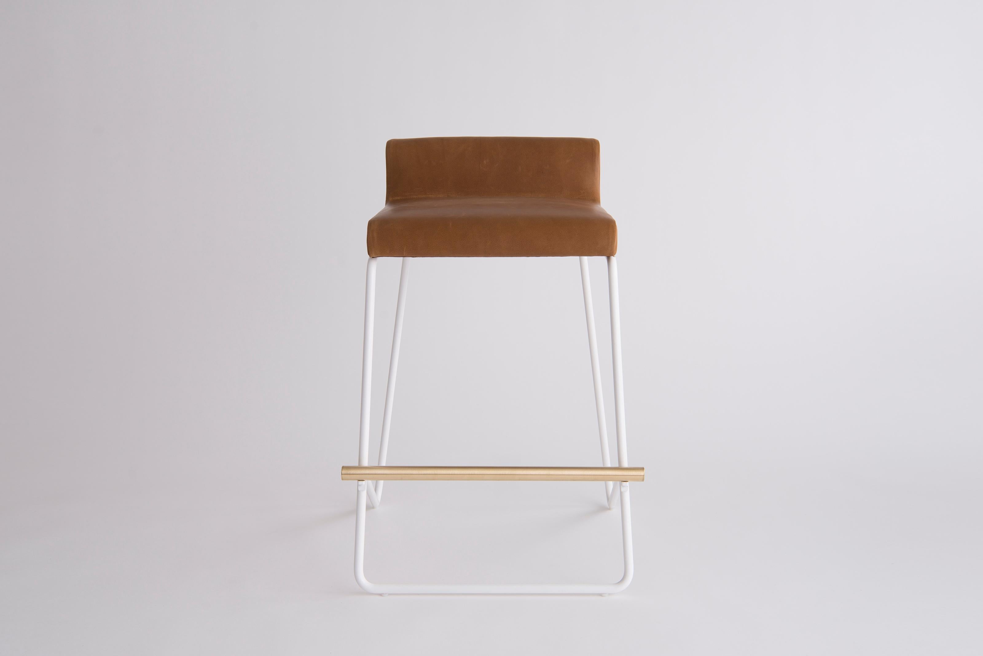 Kickstand Counter Stool by Phase Design
Dimensions: D 57.2 x W 52.7 x H 76.2 cm. 
Materials: Leather, powder-coated metal and brushed brass.

Solid steel bar available in a flat black or white powder coat finish with solid brushed brass bar and