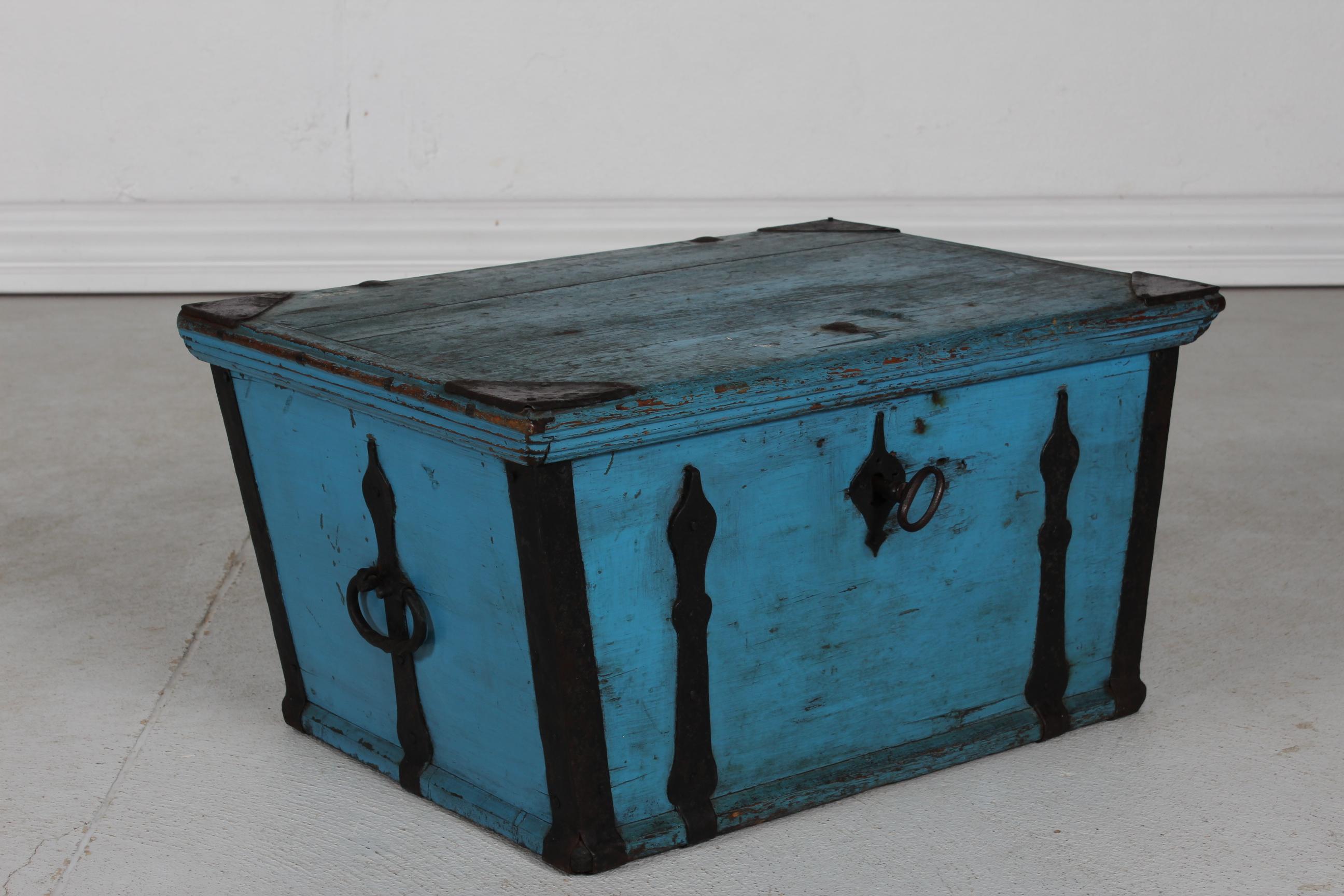 Antique Swedish campaign chest/storage box with plain top lid - can be used as a small table.
It's  made of pine wood with blue paint patinated after use and age.
The chest has a flat lid and iron fittings. The original old lock and  key is still