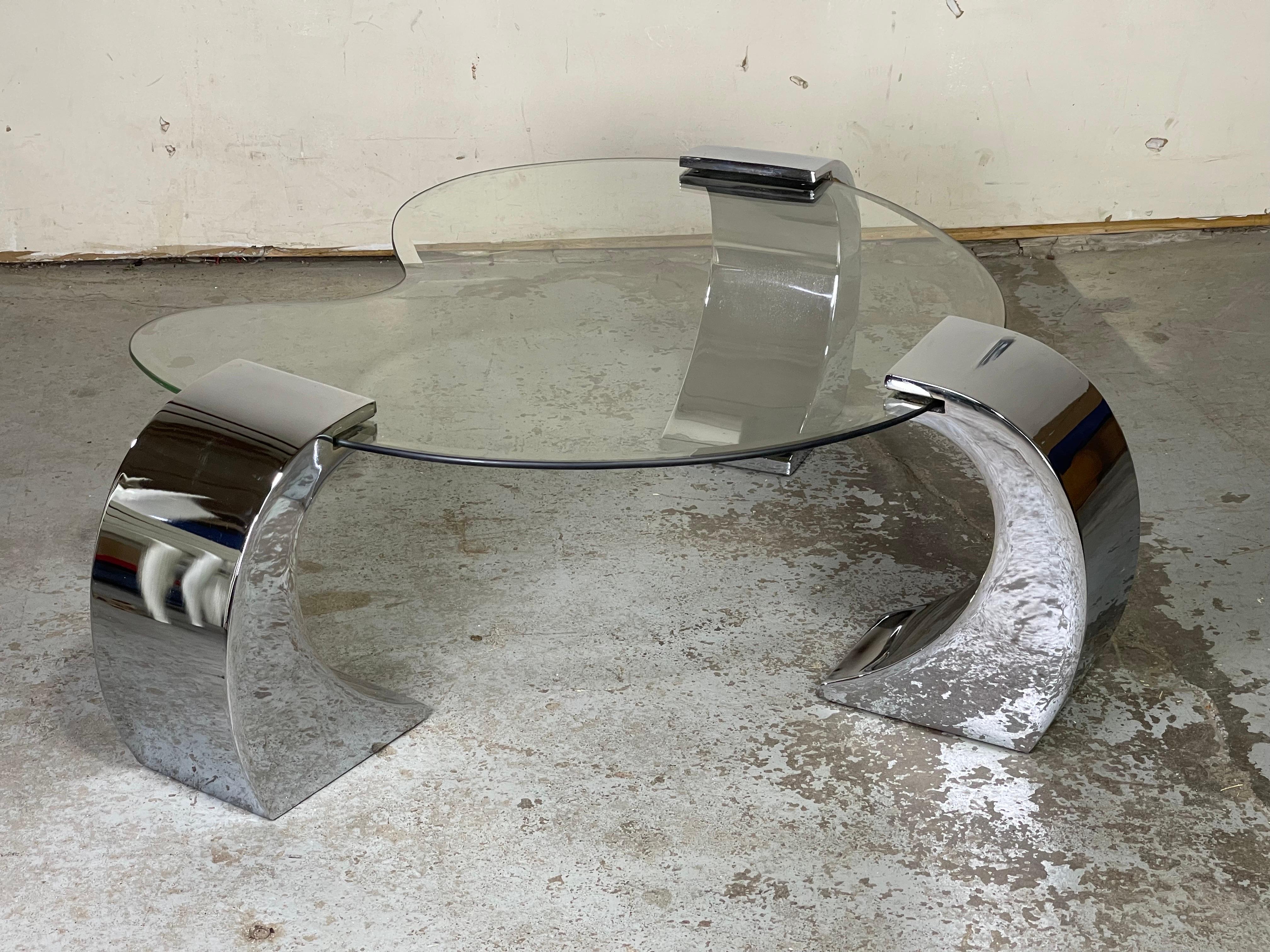 Chrome and glass kidney shape coffee table attributed to Pierre Cardin, in the style of Karl Springer. Great looking table. Chrome supports are moveable to fit your space. 
Chrome supports have spots of wear. Please see pictures.
Glass top has
