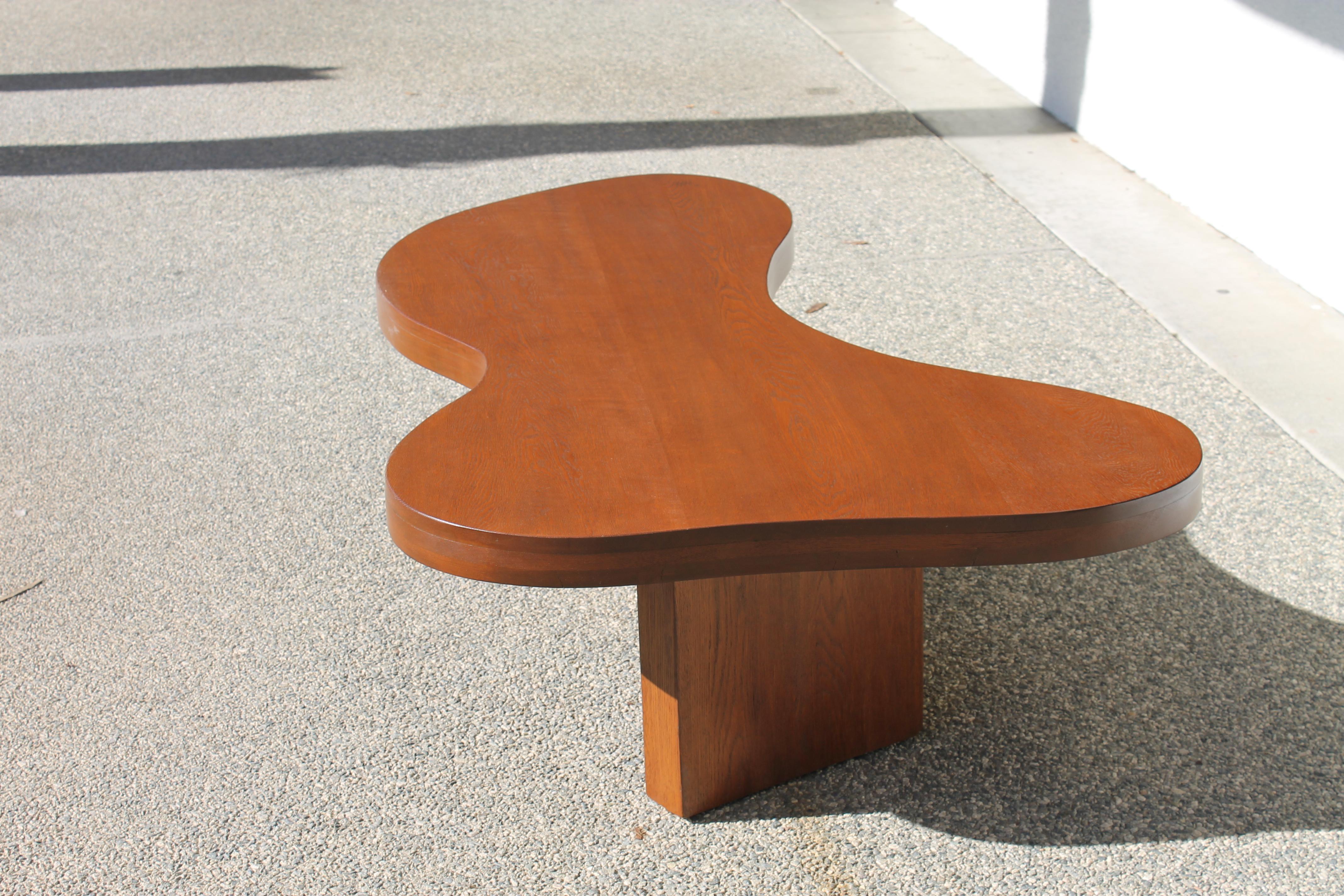 Solid oak kidney shape coffee table.  We believe this coffee table might be either John Keal for Brown Saltman or Greta Grossman for Glenn of California. Table measures 61