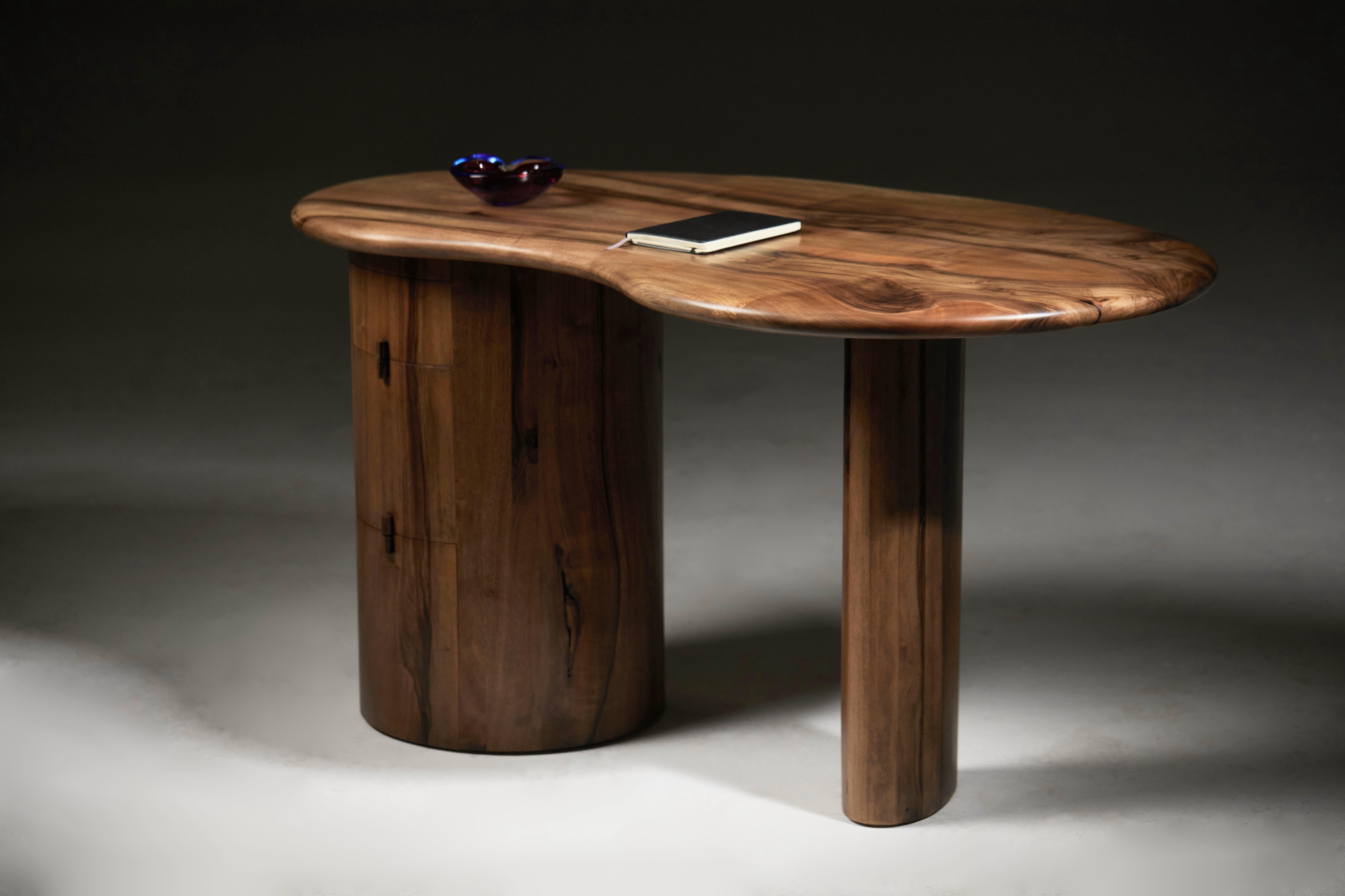 Kidney-shaped desk with a soft pebble-edge top in solid European walnut by Jonathan Field.
Each of the three drawers uses fully extendable soft-close drawer runners that provide full access to the drawer's internal depth.
The finish is a matt hard