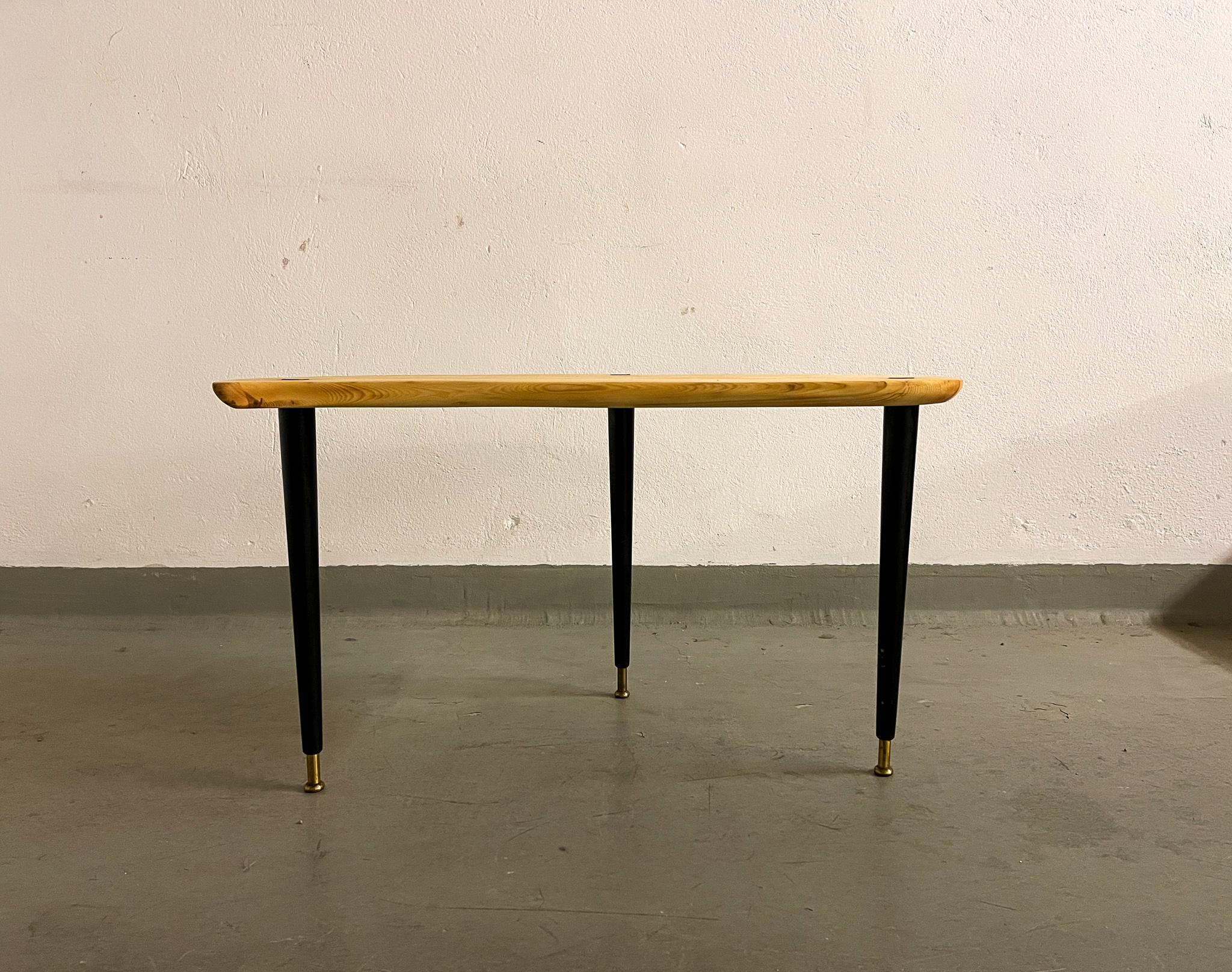 Nicely shaped organic formed side table in pine and brass with black lacquered legs. The legs with brass finish and the top with rounded brass details. Made in Sweden at Svensk Fur. 

Good vintage condition with the surface of the table