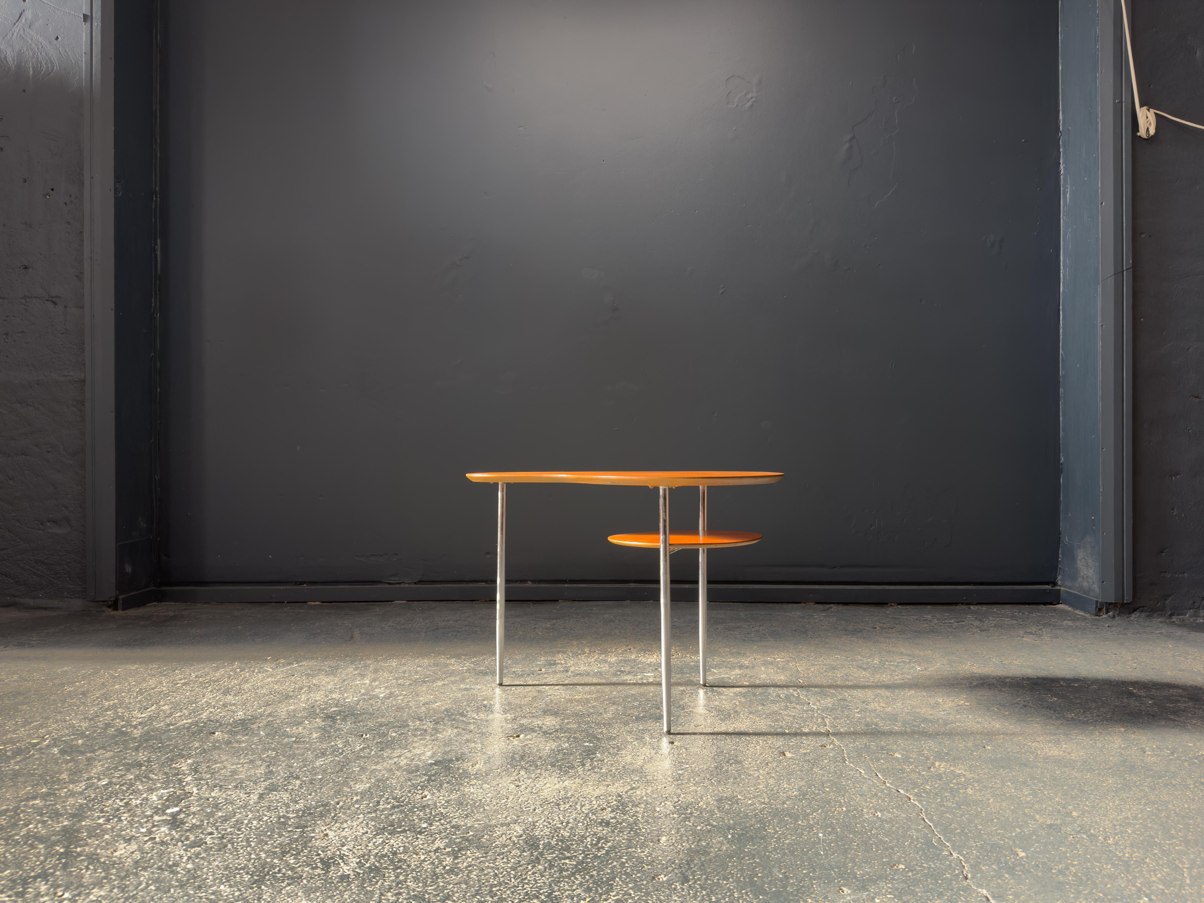 Élégante, sculpturale et ludiquement moderne, cette table basse en teck et chrome est un exemple frappant de l'innovation du milieu du siècle. Le plateau de table en forme de rein apporte une silhouette organique et fluide à la pièce, adoucissant le