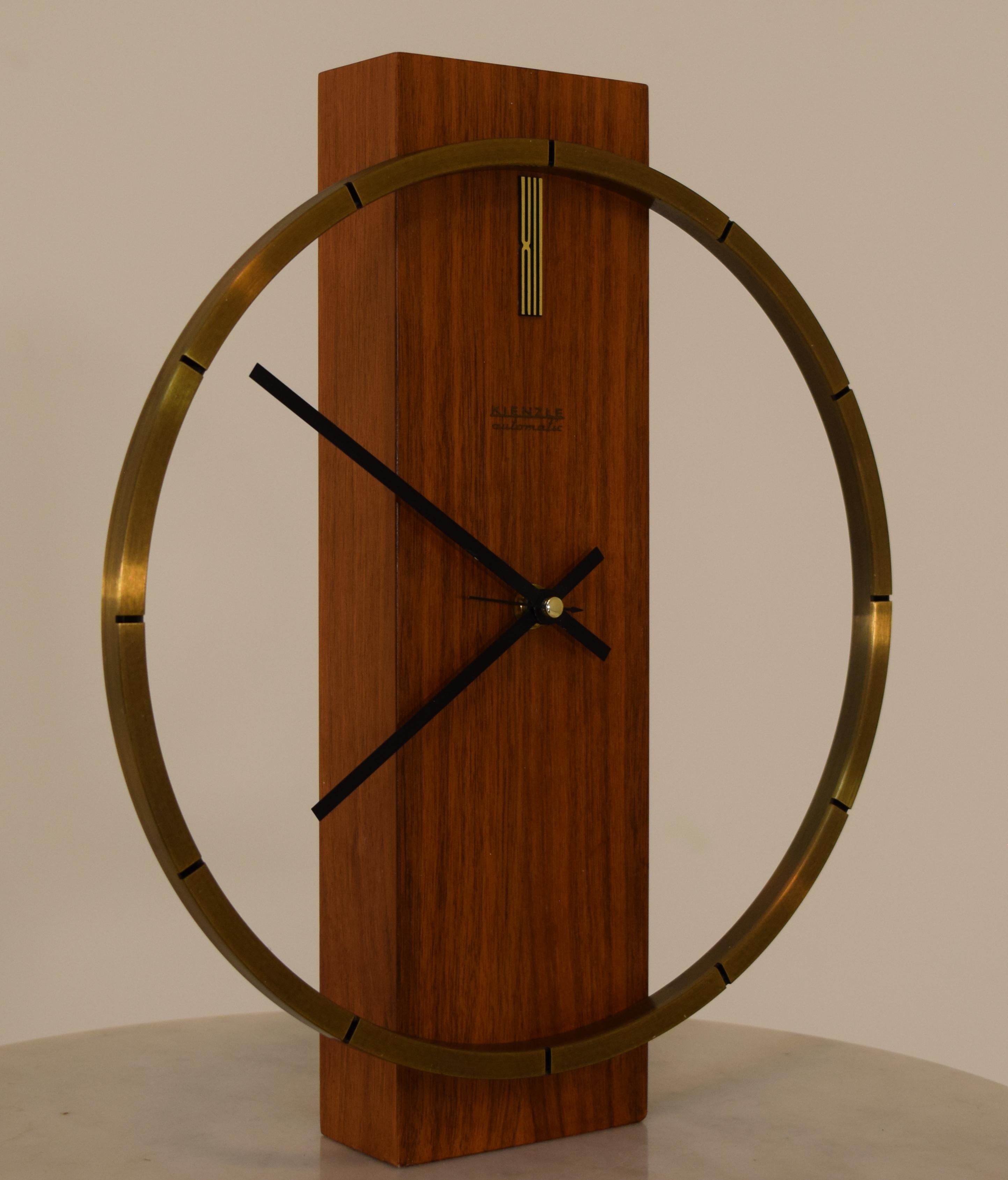 Minimalist design, produced in Germany by Kienzle Uhren, this clock may be mounted to a wall or sit upon a mantle. This model differs from others seen from the era in the omitted 