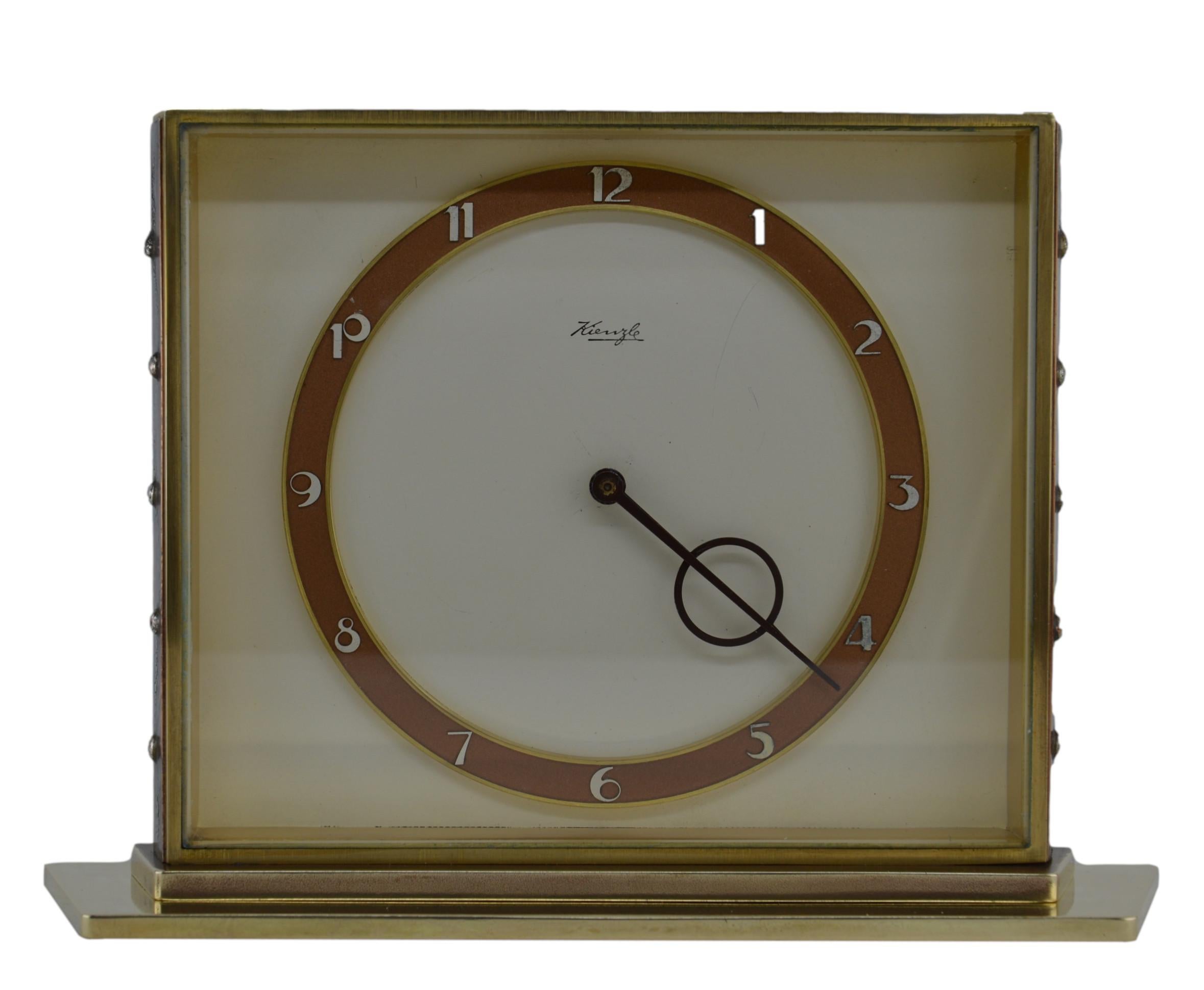 This mid-century German table clock, created by Kienzle in Germany in the 1950s, is a vintage masterpiece. A rare design. Featuring a luxurious combination of brass and bevelled glass, the clock displays exceptional craftsmanship. Its 8-day movement