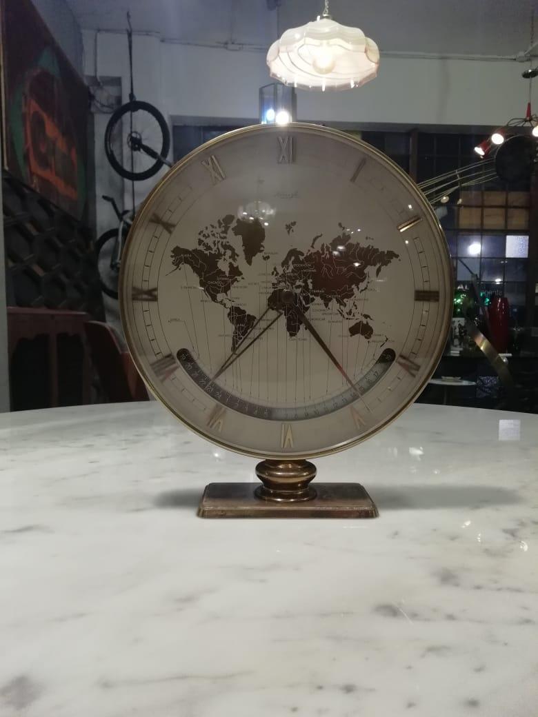 Important Mid-Century Modern brass and glass world time zone clock by Kienzle. Designed by Heinrich Möller. 25.5 cm. (10 in) Ø brass case with world map and rotating time zones. Roman numbers and sword-shaped hands. With its original mechanical