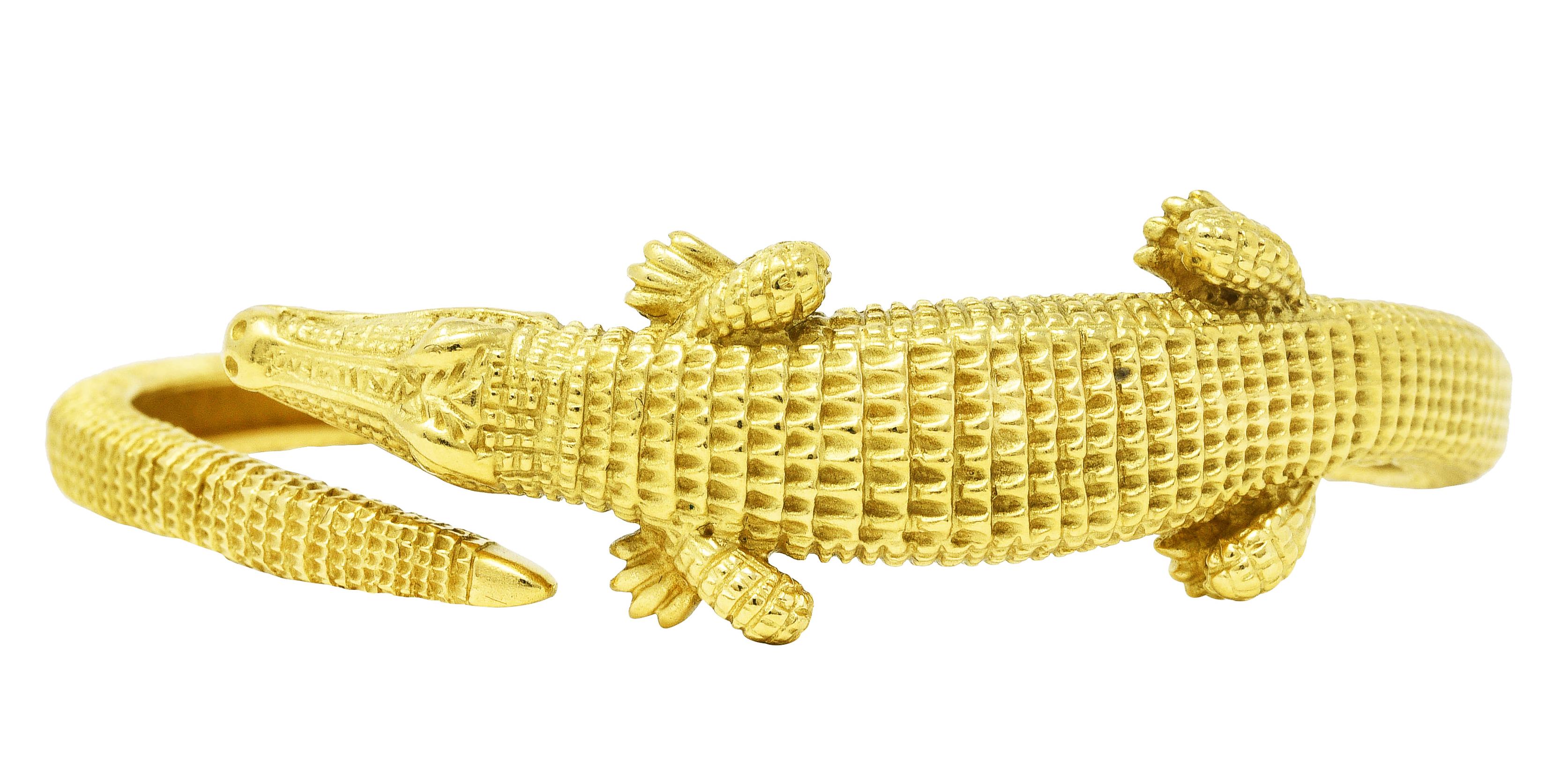 Armreif ist als stilisierter Alligator mit verlängertem Schwanz gestaltet

Durchgehend mit tief gerillten Skalen ausgestattet

Mit detailliert wiedergegebenen Gesichtszügen

Armband öffnet sich an einem Scharnier

Gestempelt 18k 750 für 18 Karat