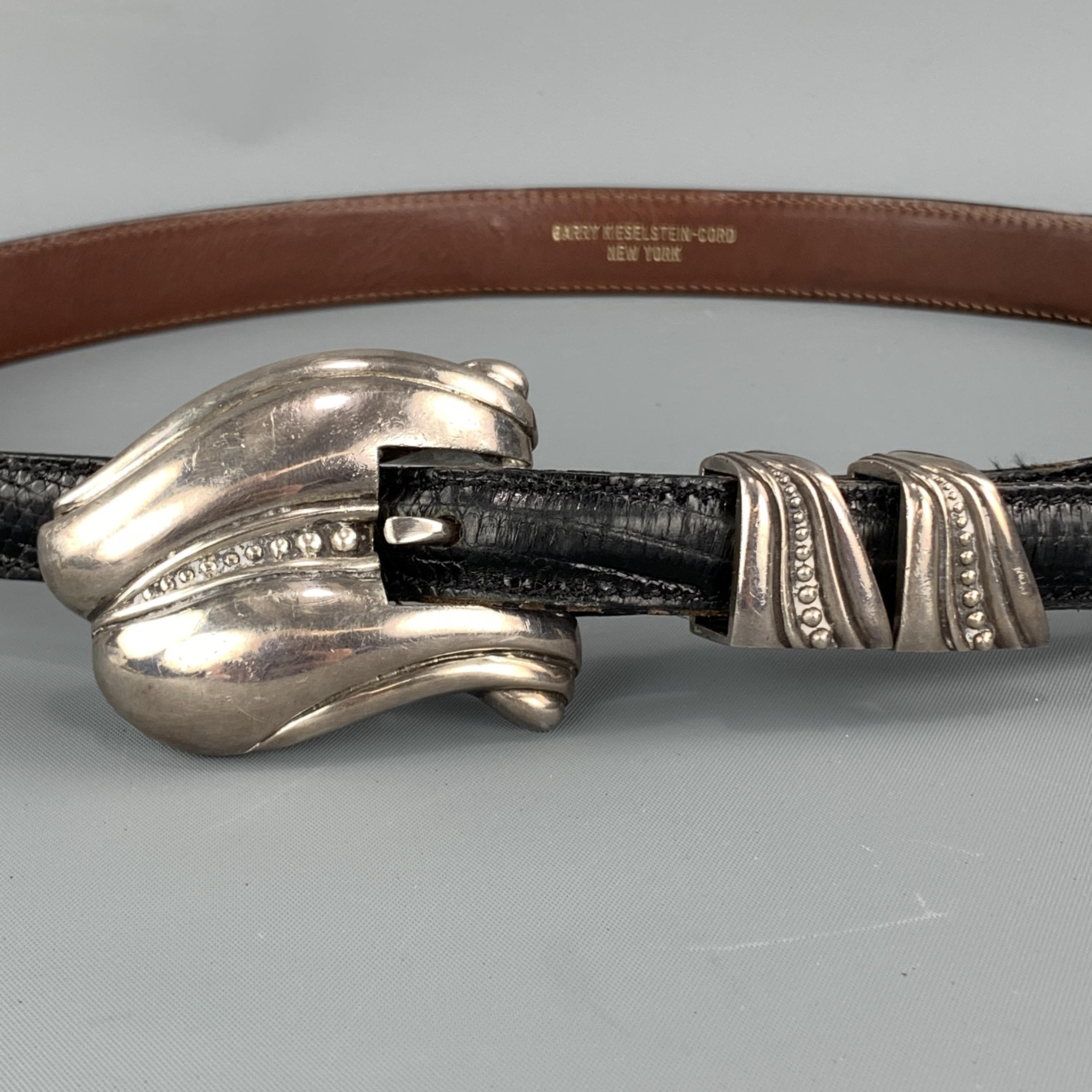 Vintage KIESELSTEIN-CORD Western belt features a black lizard leather strap with sterling silver buckle and details. Wear throughout. As-is. 

Good Pre-Owned Condition.
Marked: B

Length: 40 in.
Width: 0.75 in.
Fits: 26.5-30.5 in.
Buckle: 2.5 x 1.75