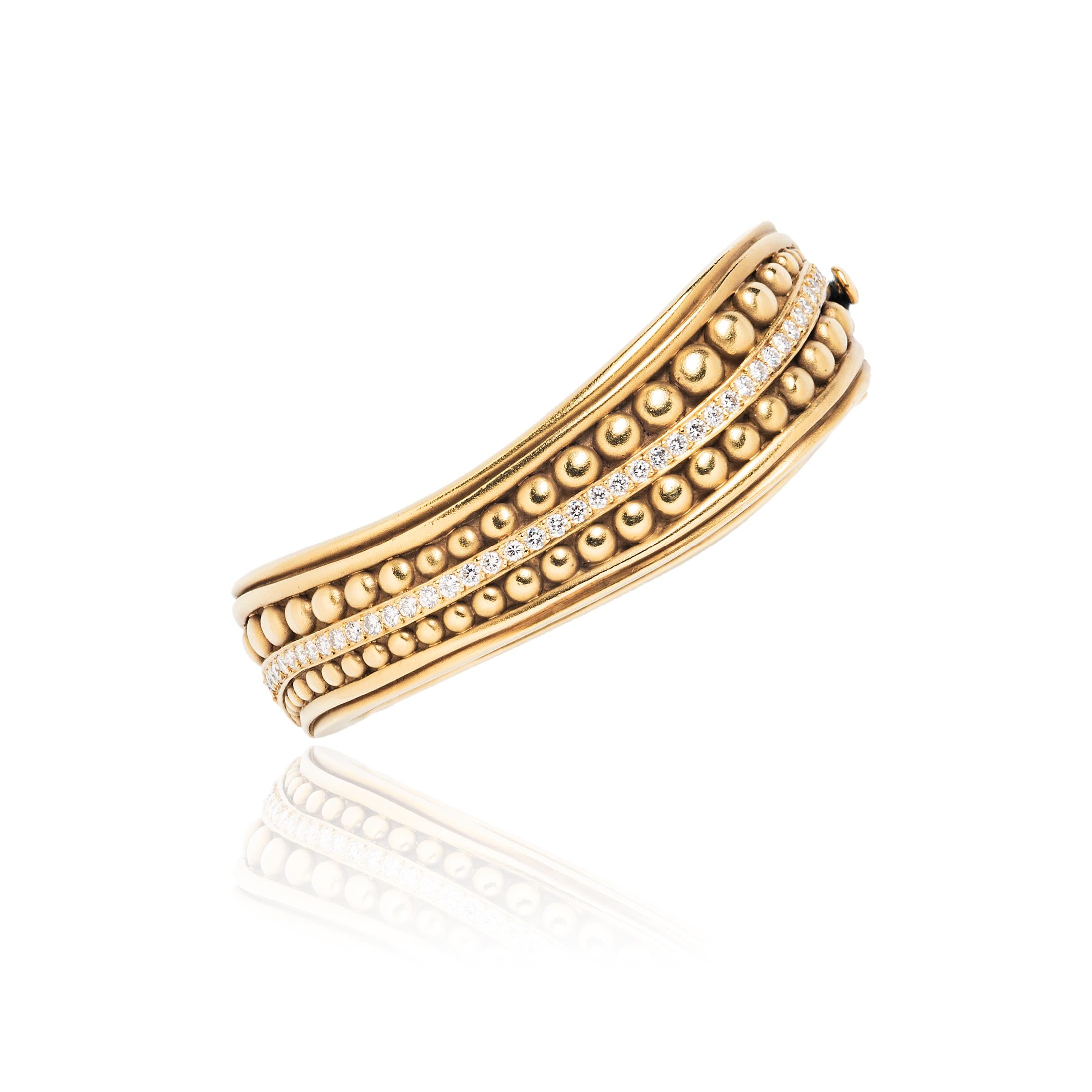This vintage caviar bangle from famed jeweler Barry Kieselstein-Cord is made of solid, hammered 18k gold accented by a sweep of round brilliant cut diamonds. It has an elegant sculptural shape with grooved and beaded textures.  

- Interior