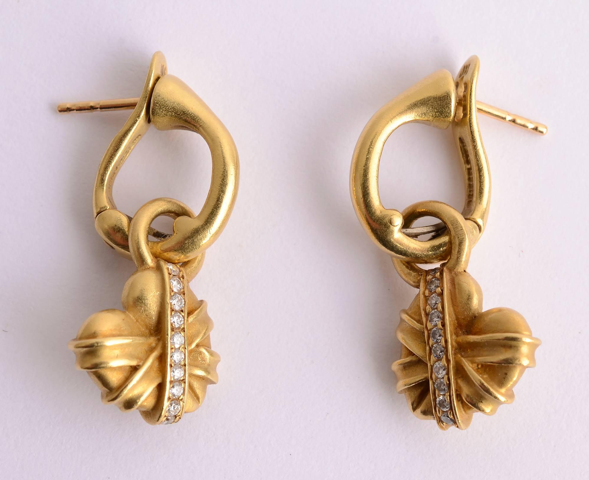 Versatile earrings by Barry Kieselstein Cord. They can be worn with a dangling heart wrapped in diamonds or with the heart removed as a small hoop. With the heart, they measure 1  1/8 inches in length. The hoop alone is half an inch in length. The