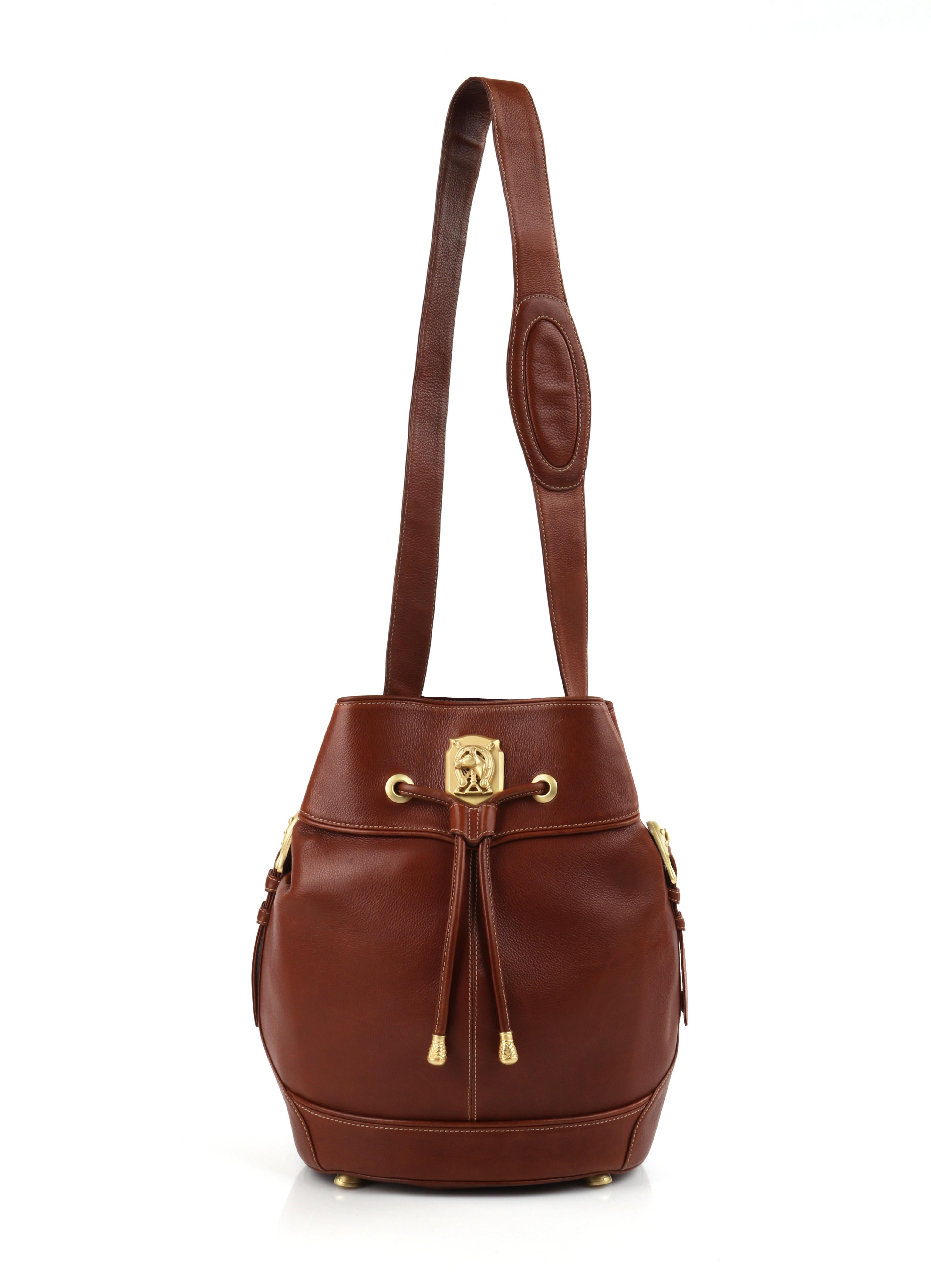 KIESELSTEIN-CORD Leather Drawstring Equestrian Medallion Bucket Shoulder Bag
  
Brand / Manufacturer: Kieselstein-Cord 
Designer: Barry Kieselstein-Cord
Style: Bucket bag
Color(s): Shades of warm brown (exterior); shades of emerald green (interior);