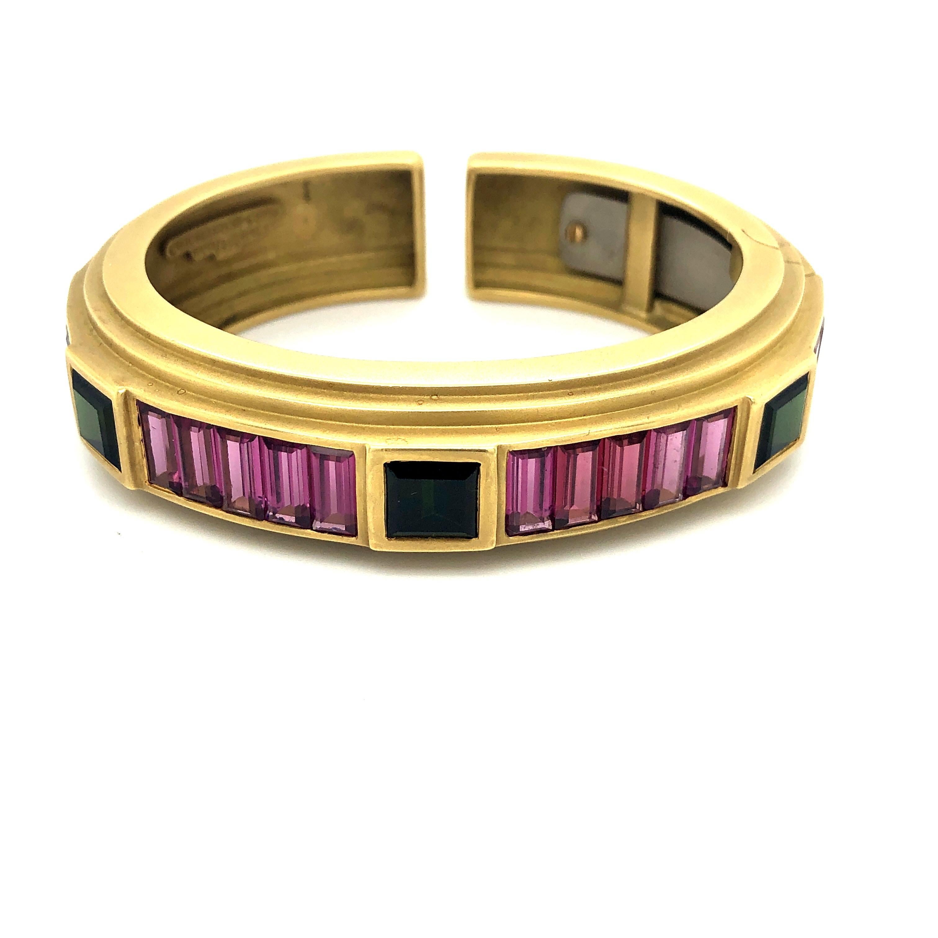 Stamped 18K this yellow gold bracelet holds pink and green tourmalines in a unique setting.  Fits a standard size 7-7.5 wrist.  