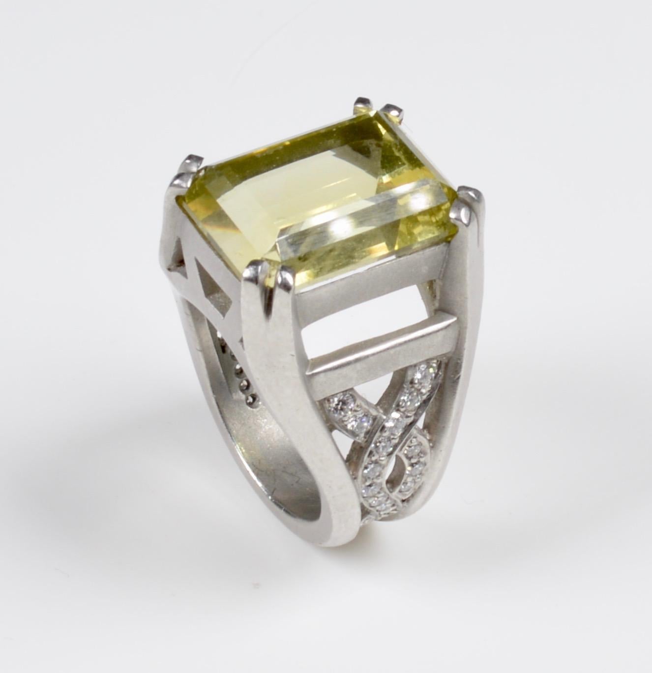 A platinum, beryl and diamond ring by renowed New York jewellers Kieselstein-Cord, circa 1998. 
This stunning ring contains one octagonal step cut yellowish green beryl weighing approximately 11.79 carats and 42 round brilliant cut diamonds weighing