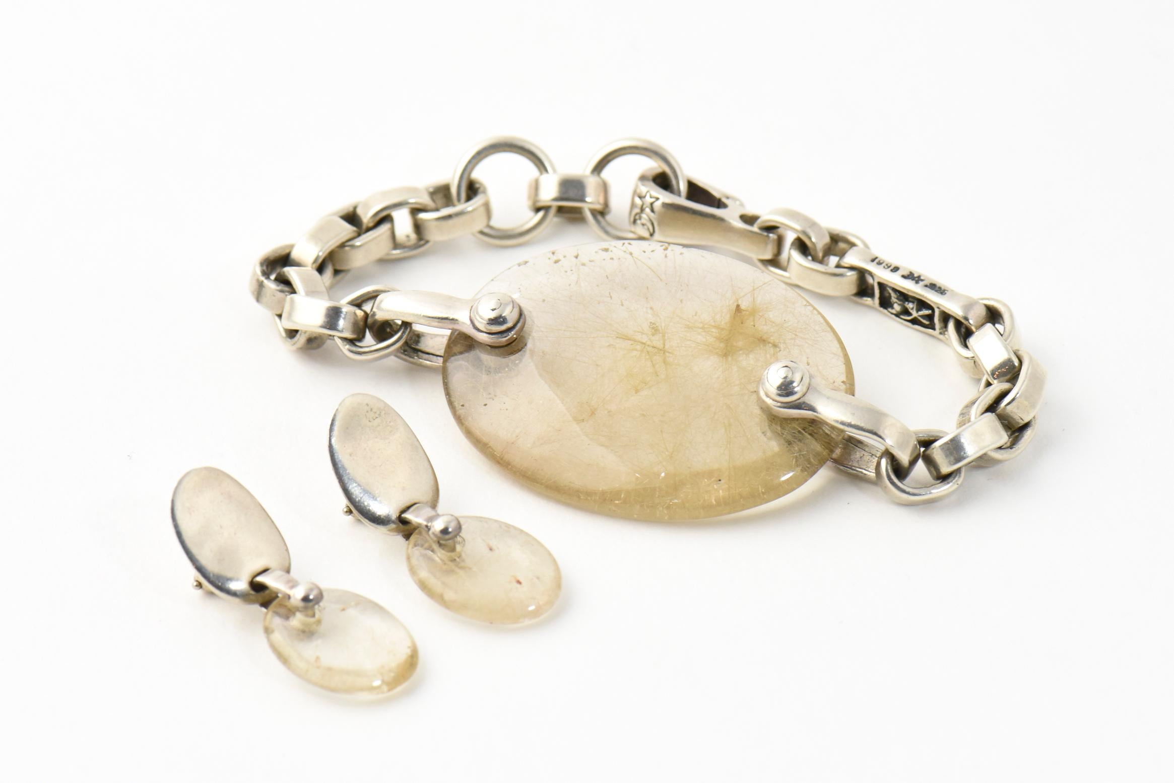 Barry Kieselstein-Cord oval rutilated quartz charm on sterling silver oval link chain bracelet and hinged clip closure. The matching earrings feature an oval sterling silver piece with dangling oval rutilated quartz.  The earrings are clip-on (no