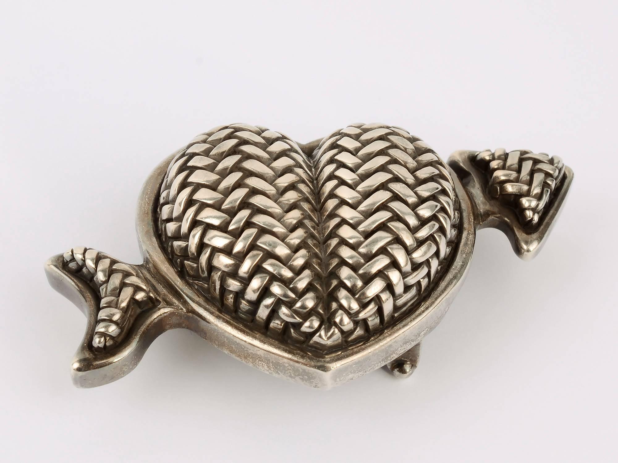 Barry Kieselstein Cord sterling silver belt buckle of a heart with an arrow going through. It is dated 1997. The buckle is wonderfully three dimensional and textured with a herringbone design. It measures 1 3/4 inches tall and 3 1/4 inches across