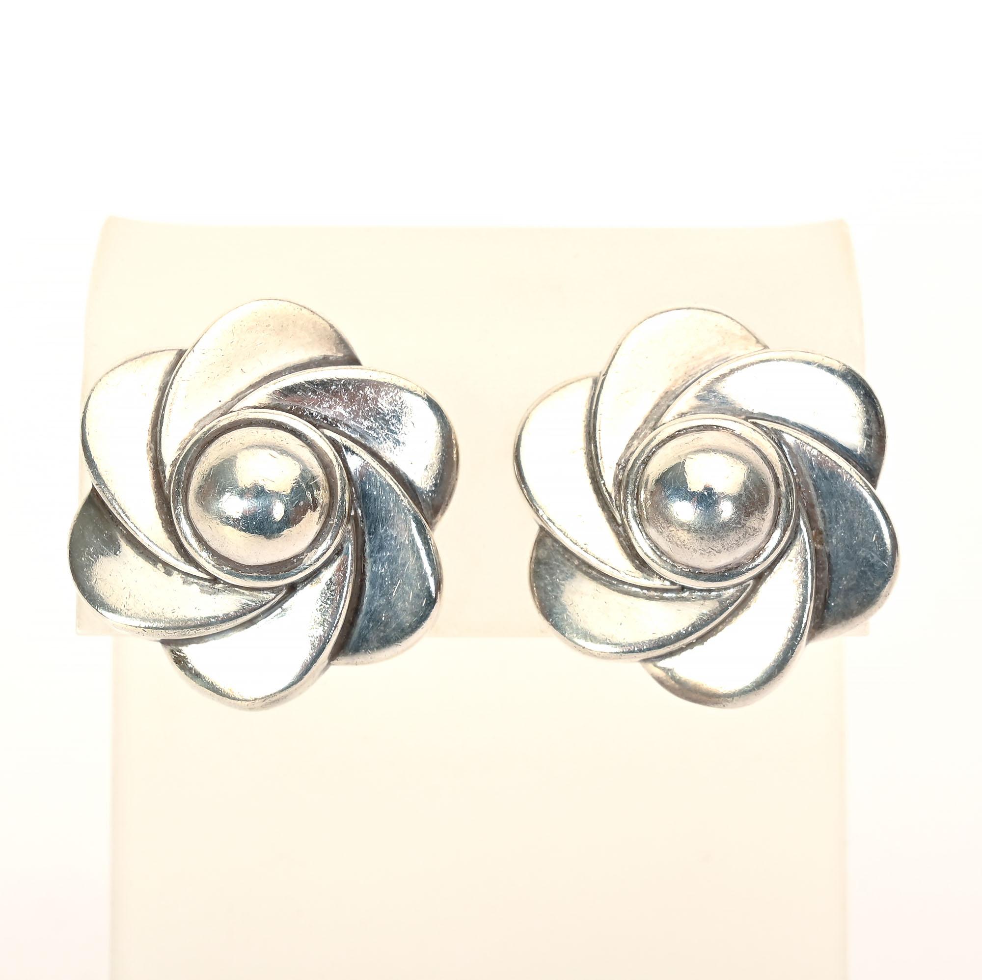 Sterling silver earrings in the form of stylized flowers by America's premier 20th century designer, Barry Kieselstein Cord. The earrings have domed centers and swirling petals. They measure 7/8