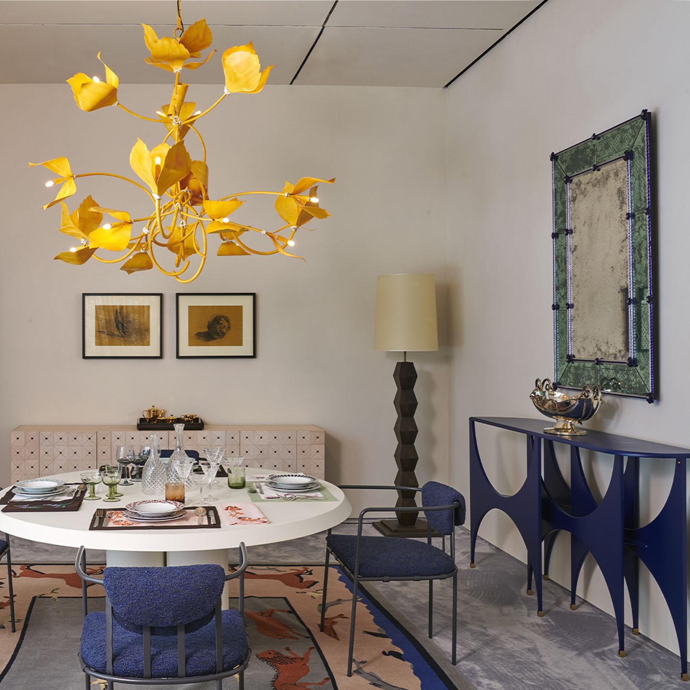 Kigelia è una lampada da terra rigorosa con un design fortemente geometrico. Si compone di uno stelo con elementi modulari ripetuti a forma di rombo in legno massiccio con finitura in noce massiccio scuro e di un paralume cilindrico classico con