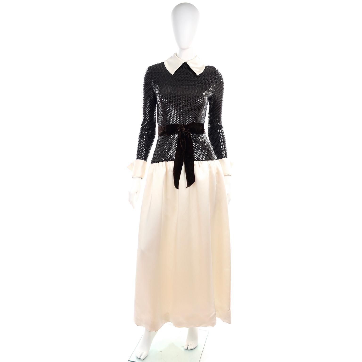 This is a lovely vintage dress designed by Kiki Hart in the late 1960's or early 1970's.  The dress has a brown/black sequin bodice and ivory satin long skirt, cuffs and collar.  .The dress has a brown velvet belt and 2 functional pockets. There is