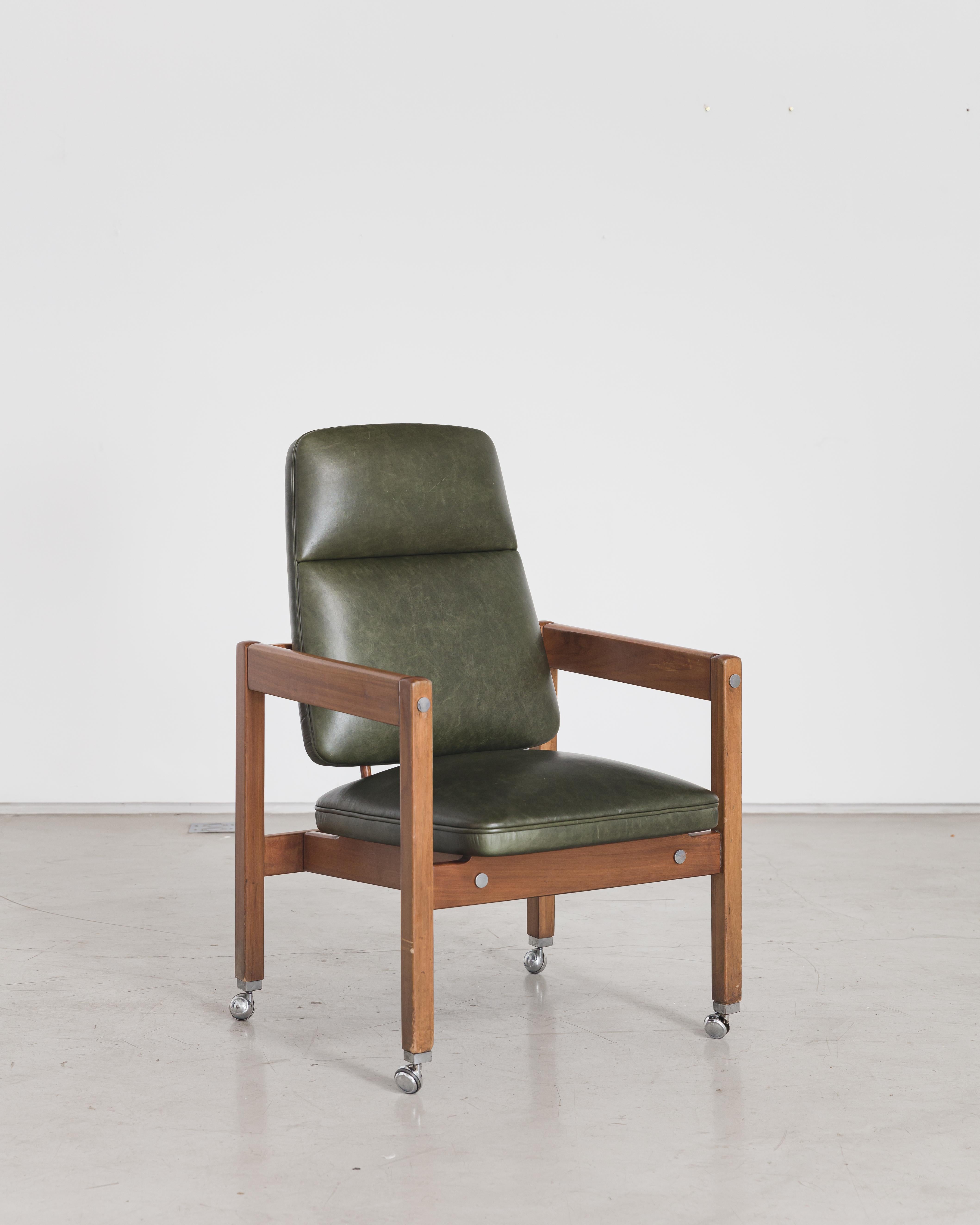 Fabriquée en bois de rose Jacarandá, cette pièce de Sergio Rodrigues est originellement tapissée de cuir vert, avec des accents circulaires chromés et des roulettes chromées. Cette chaise a été créée pour meubler le bâtiment Palacio dos Arcos,