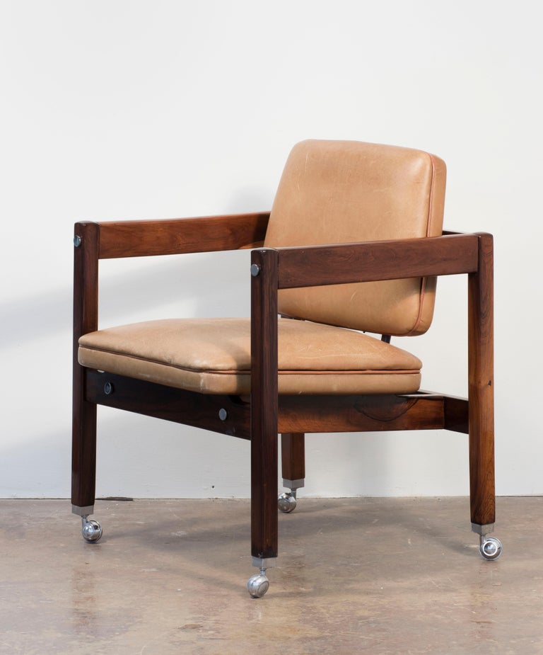 Made in Jacarandá rosewood, this Sergio Rodrigues piece has originally upholstered in yellow leather, circular chrome accents, and chrome casters. This chair was created to furnish the Palacio dos Arcos Building, Ministry of Foreign Affairs, in