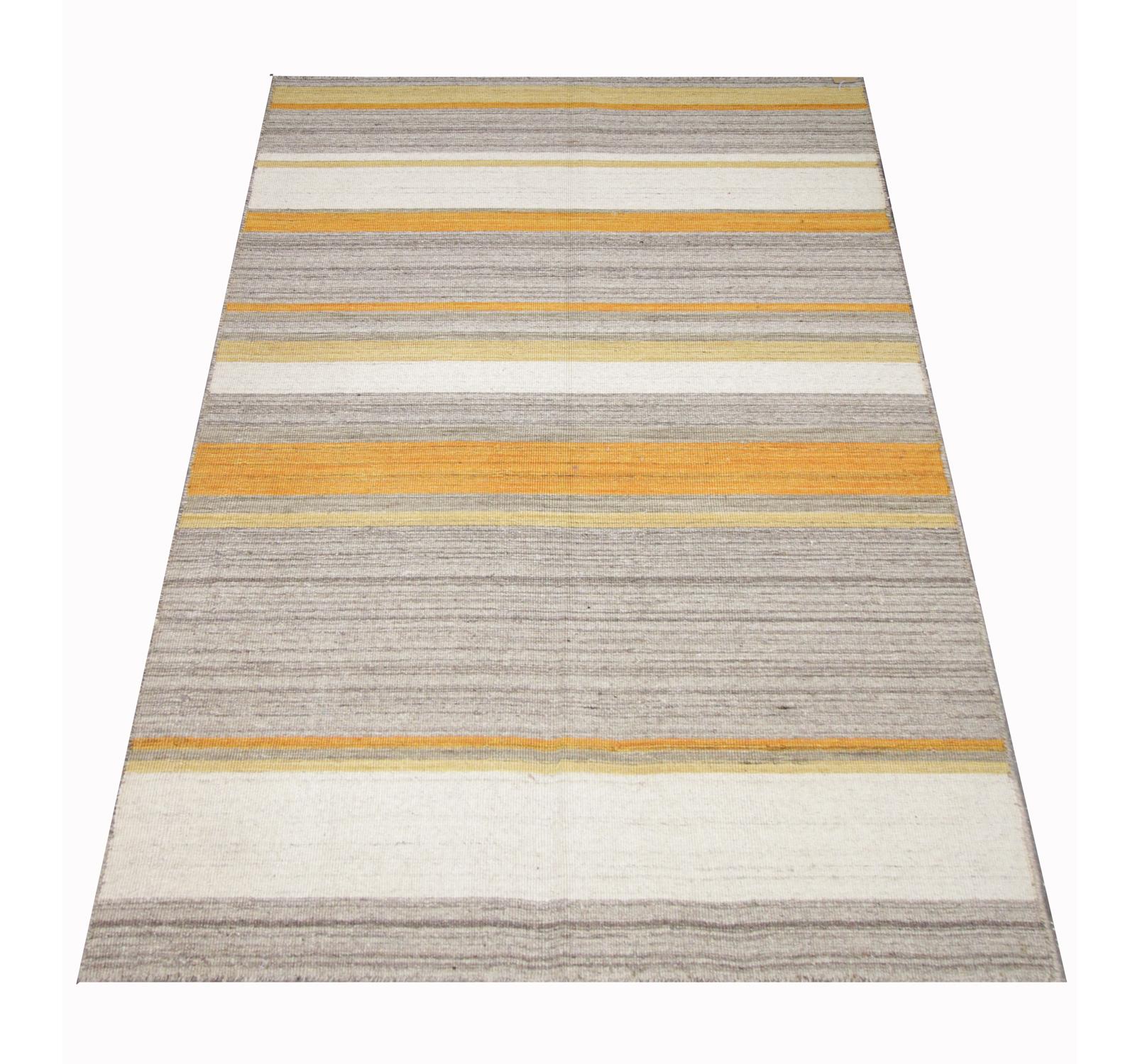 This piece is a modern kilim woven with a simple contemporary design. Grey, cream and yellow stripes make up the abstract pattern shown in this piece. Simple yet sophisticated this piece is sure to make the perfect accent rug in any home. 
Kilim