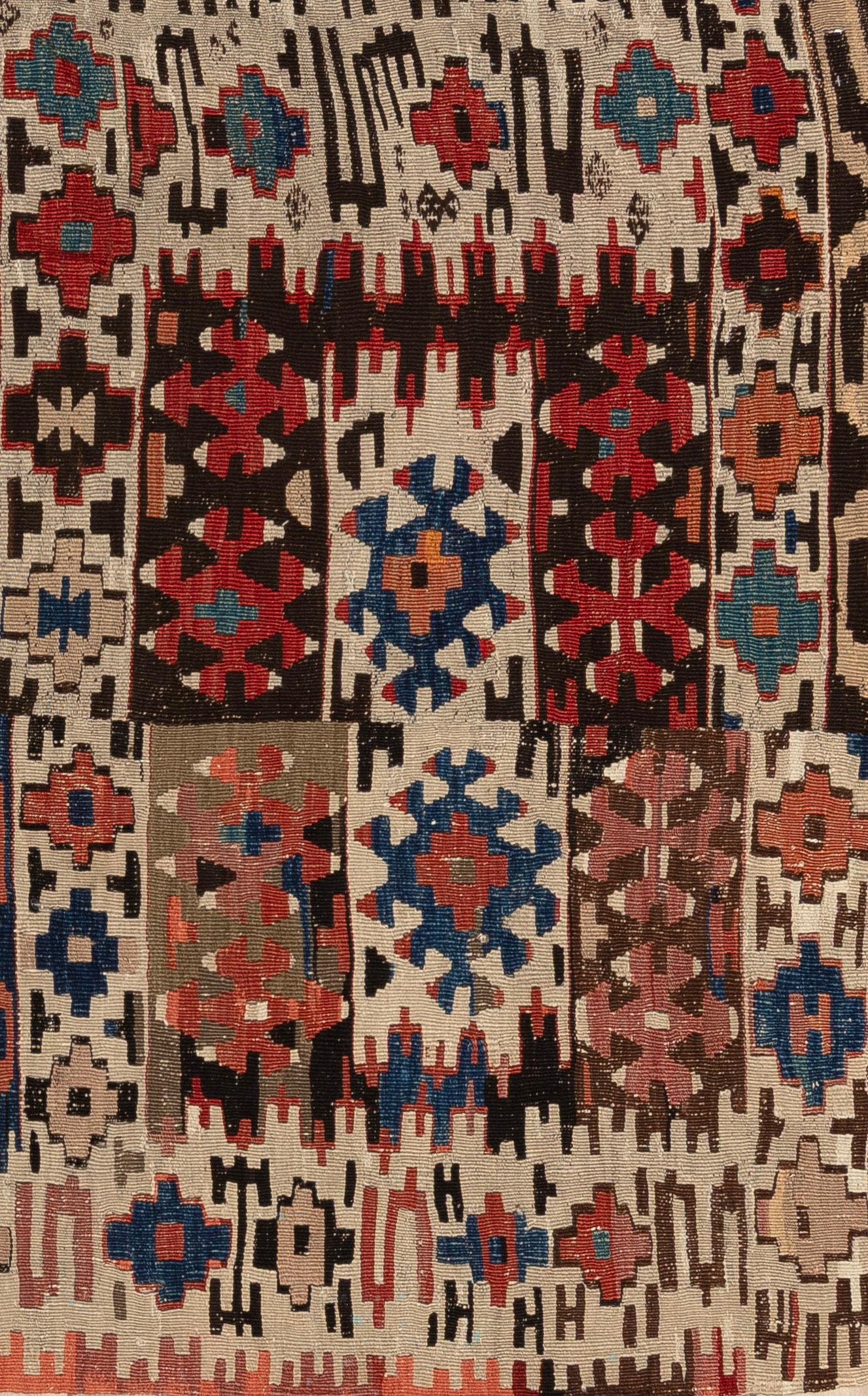 Ce kilim tribal coloré est un tissage plat vibrant qui reflète la créativité et l'héritage du tissage nomade traditionnel. Tissé à la main en laine, il présente des motifs géométriques audacieux et des motifs répétitifs qui symbolisent la