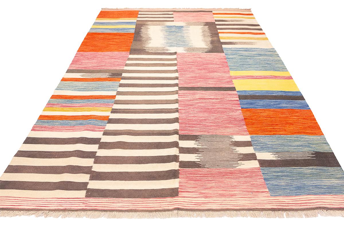 Ein lebendiger Kilim-Teppich mit einem fesselnden Harlekin-Muster, der vor Farbkraft nur so strotzt. Dieses außergewöhnliche Stück besticht durch seine einzigartigen Muster und kräftigen Farben, die es zu einer ganz besonderen Bereicherung für jeden