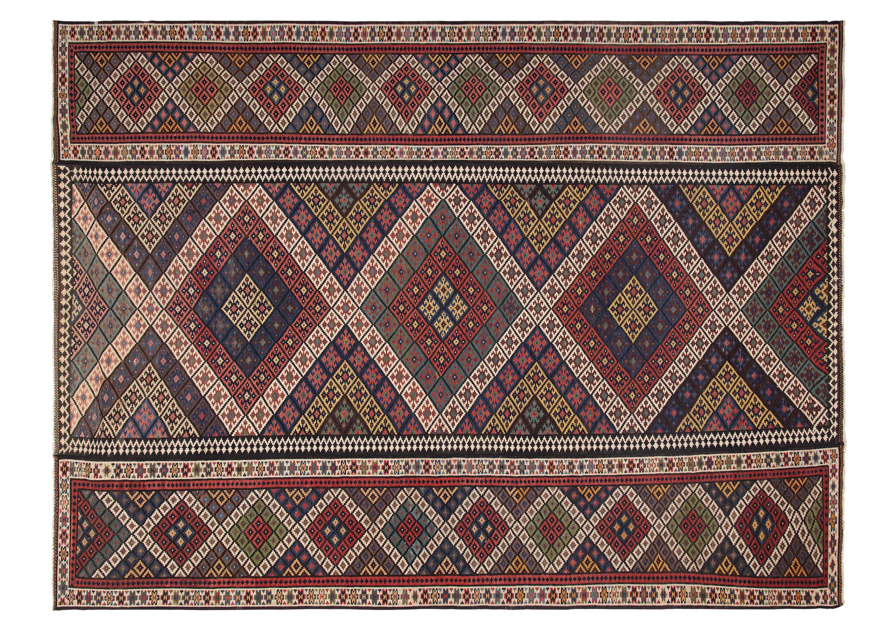 This is a vintage Kilim rug c. 1900. This rug is magnificent considering the complicity of pattern, color, and sheer size (12'9x17'3). The rug is primarily divided into three sections: one center pattern and two similar sections on either side. The