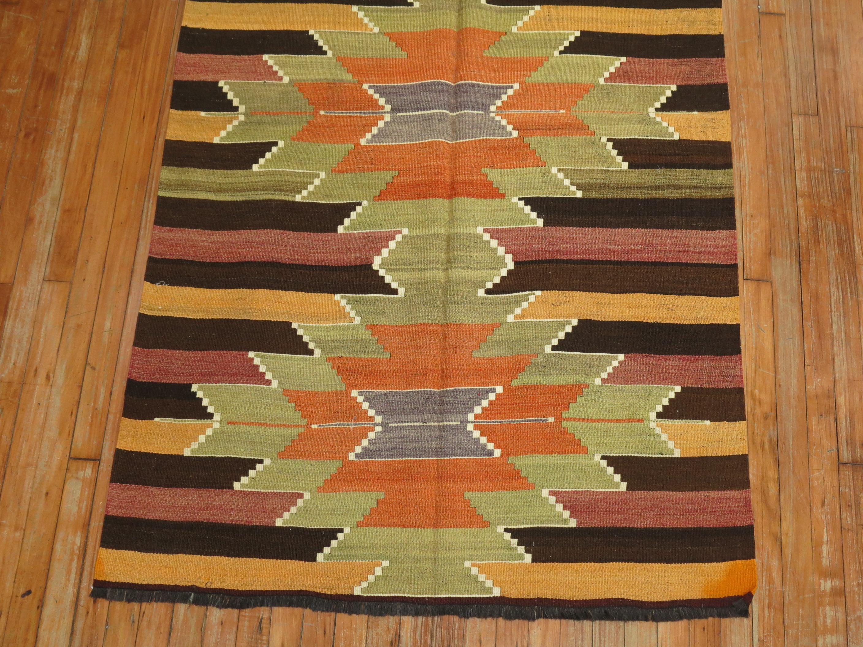 A vintage Turkish Kilim wide runner with 5 green and orange medallions on a striped ground, circa mid 20th century.
Measures: 3'10” x 10'10”.