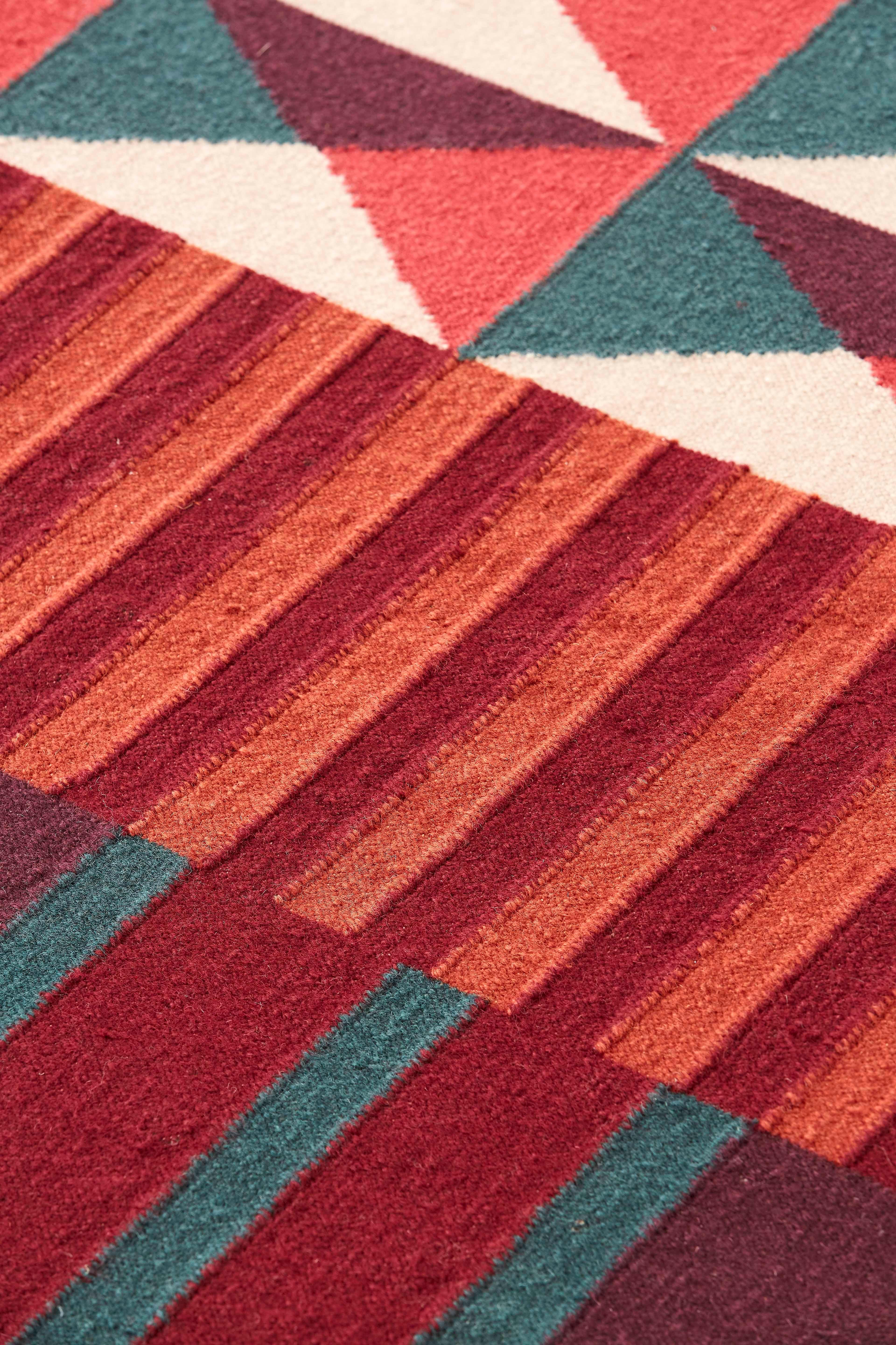 Die Ndebele-Teppiche sind von der Kultur des afrikanischen Ndebele-Volkes inspiriert, das für seine bunten Fassaden bekannt ist. Diese werden traditionell von Frauen gemalt, die ihre Häuser mit Wandmalereien mit geometrischen Motiven und leuchtenden