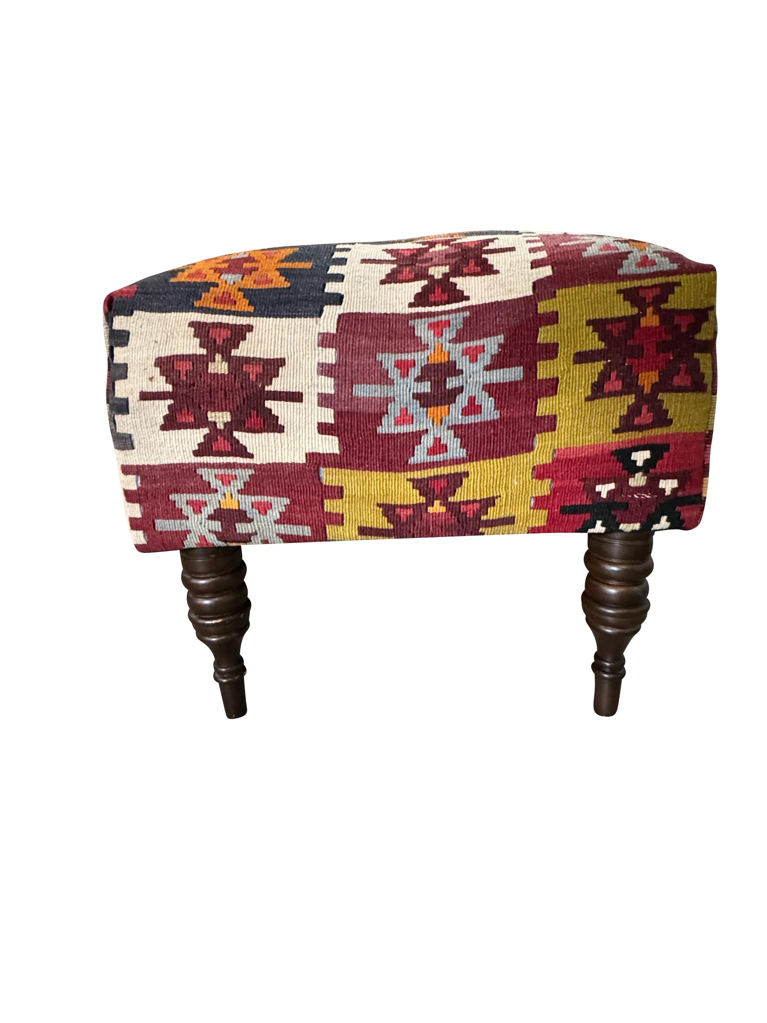 Newly upholstered turned leg bench, footstool, or window seat in a colorful and highly decorative and antique kilim.  Perfect also for an entry or foyer bench or at the end of a bed.  Colors include navy, red, green, and gold on a natural