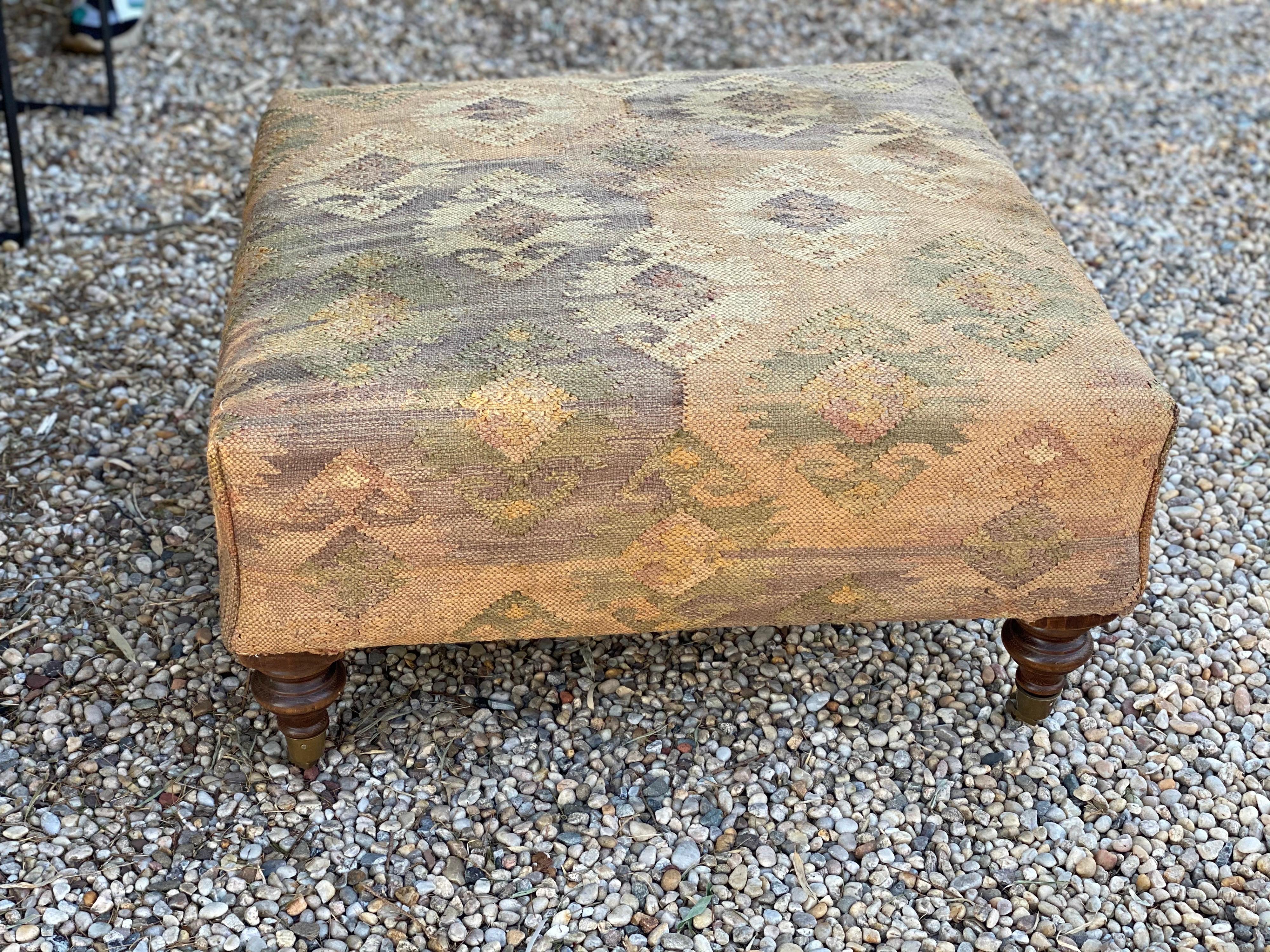 Kilim upholstered ottoman/coffee table by George Smith. Turned wooden legs on brass casters.
Reupholstered in vintage Kilim. George Smith tag was taken off in re-upholstery. Discolorations to Kilim. Good overall condition.
Measures: 32” square x