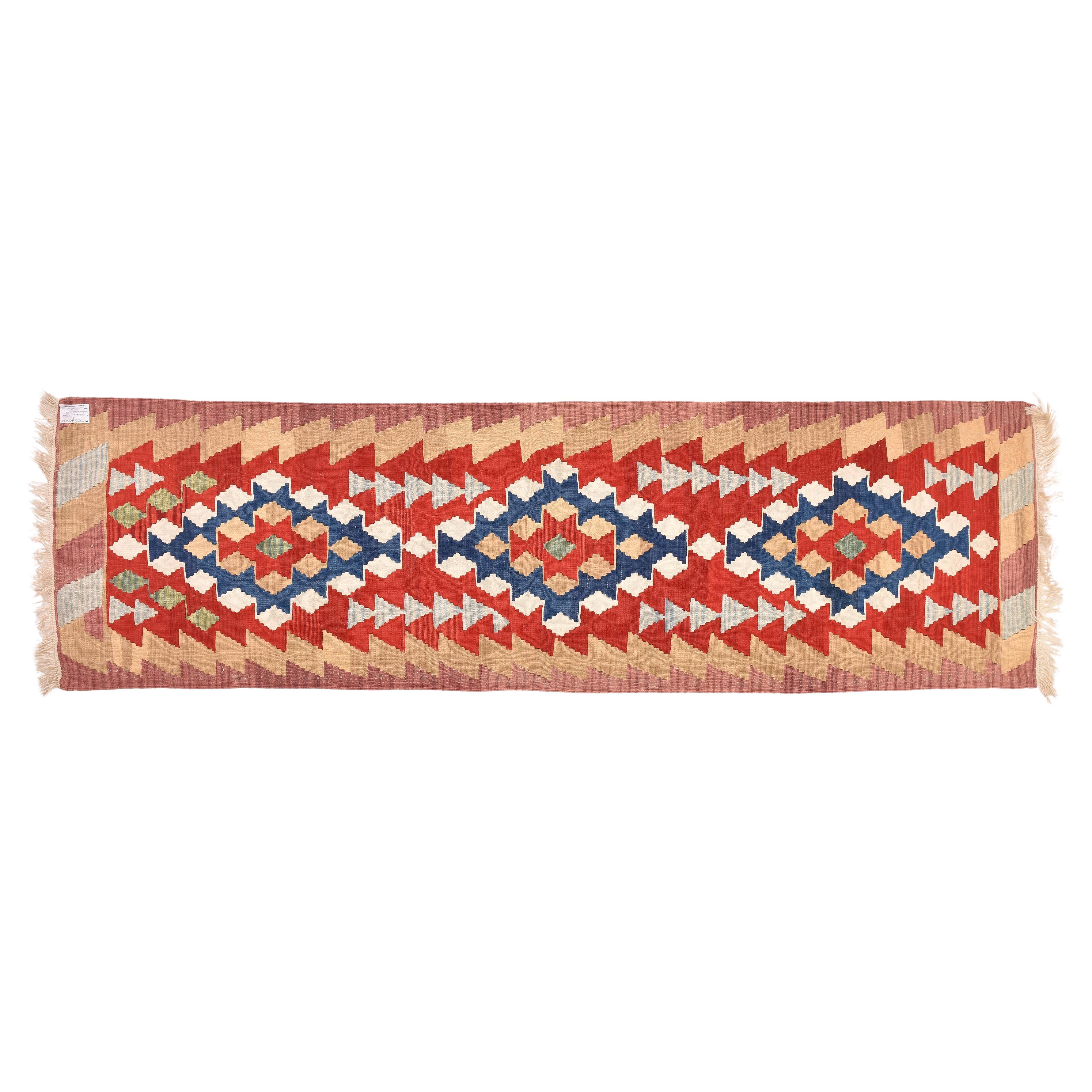 nr. 1144 -  Beautiful Turkish kilim runner, with cheerful colors (red, white, blue) in three geometric medallions, enclosed in a pink and camel border.  Robust and pleasant, with a good price.