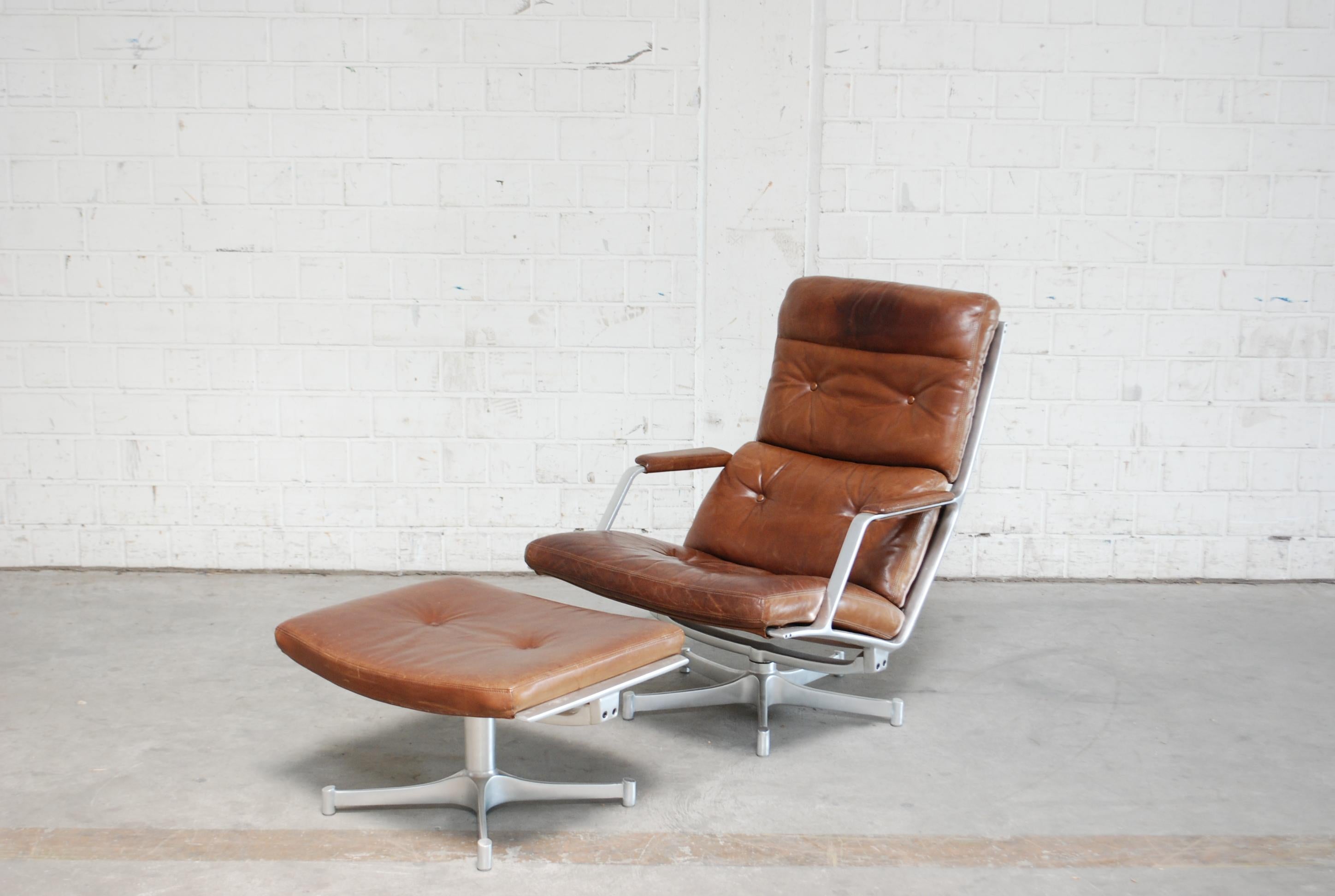 FK 85 was made by Jorgen Kastholm & Preben Fabricius for Kill international
The lounge chair and ottoman has an swivel aluminium frame and cognac Leather.
The leather has patina on the headrest.
The colour is a brown cognac.