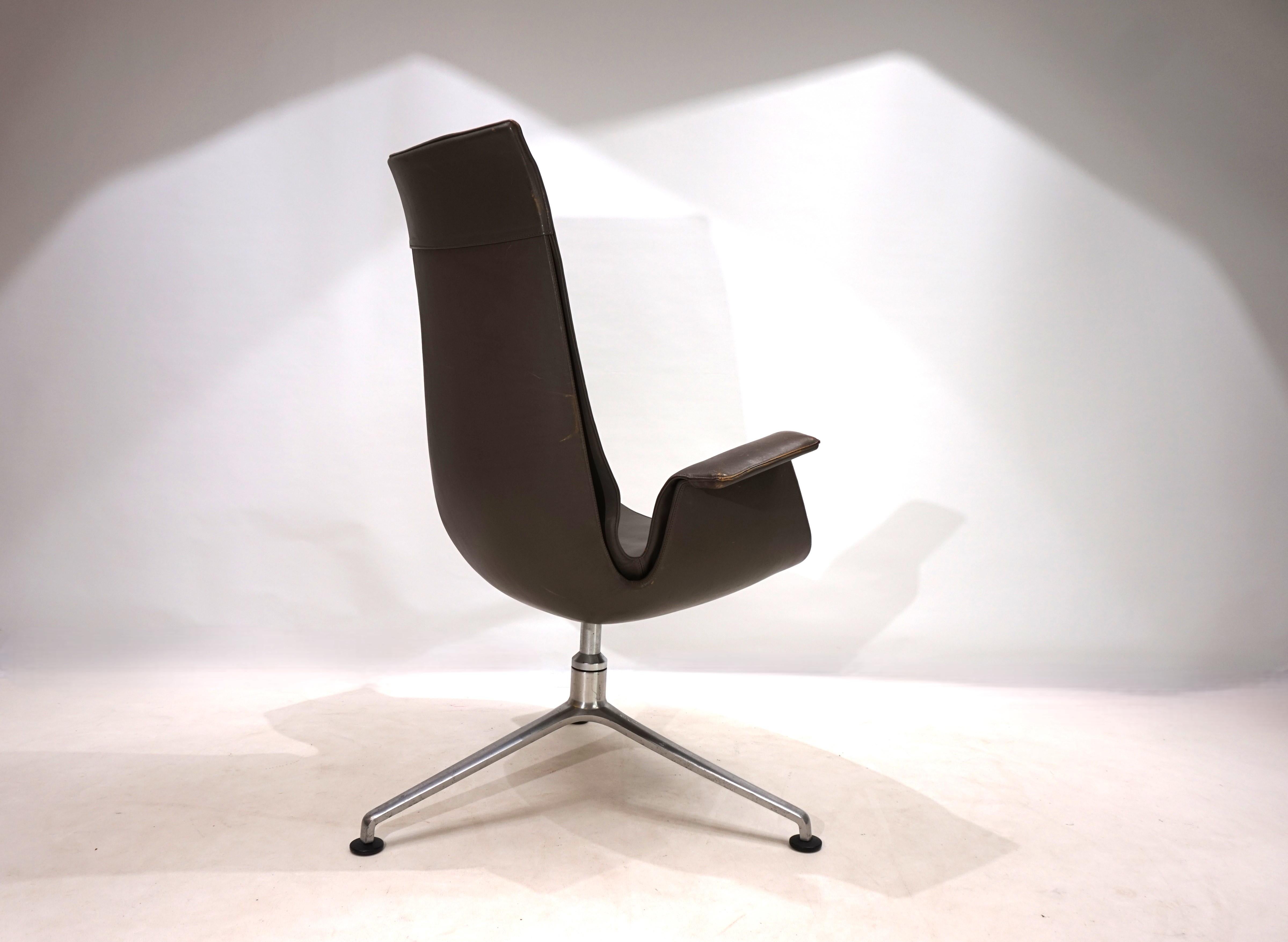An elegant FK 6725 Bird chair with a high backrest in very good condition. The taupe-colored leather of the chair shows hardly any signs of wear and has a charming patina on the armrests. The typical three-legged frame, which characterizes the lines