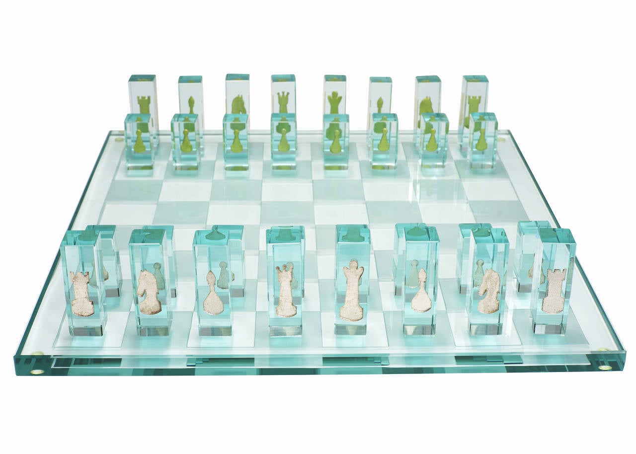 Cold-worked art glass chess set, circa 1995. This set includes a full size board and all game pieces one side finished in 24-karat white gold and another in 24-karat yellow gold.

The game board is comprise of a solid piece of kiln-formed glass