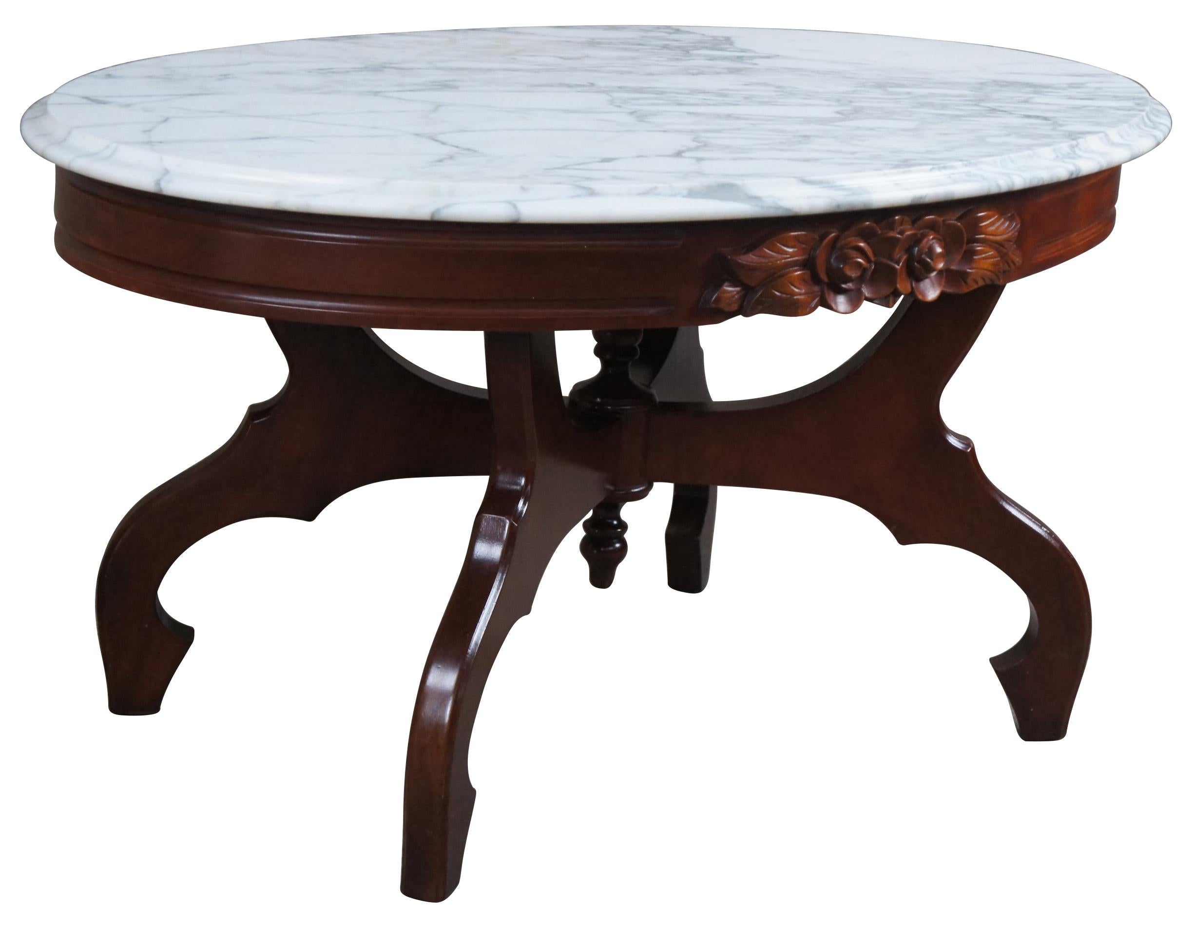 Vintage Victorian reproduction parlor table by Kimball Furniture. Made from mahogany with an oval white Italian marble top. Features a rose carved apron over a four legged base centered by finials.