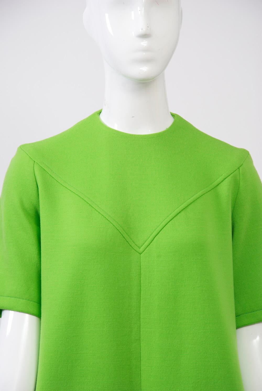 Double-knit wool dress in bright green by Kimberly, featuring A-line shape, short sleeves, a round neck and welted seaming at the integrated V and straight yoke in back; diagonal bound pockets. Back zipper. Approximate size 8. 
Kimberly Knitwear was