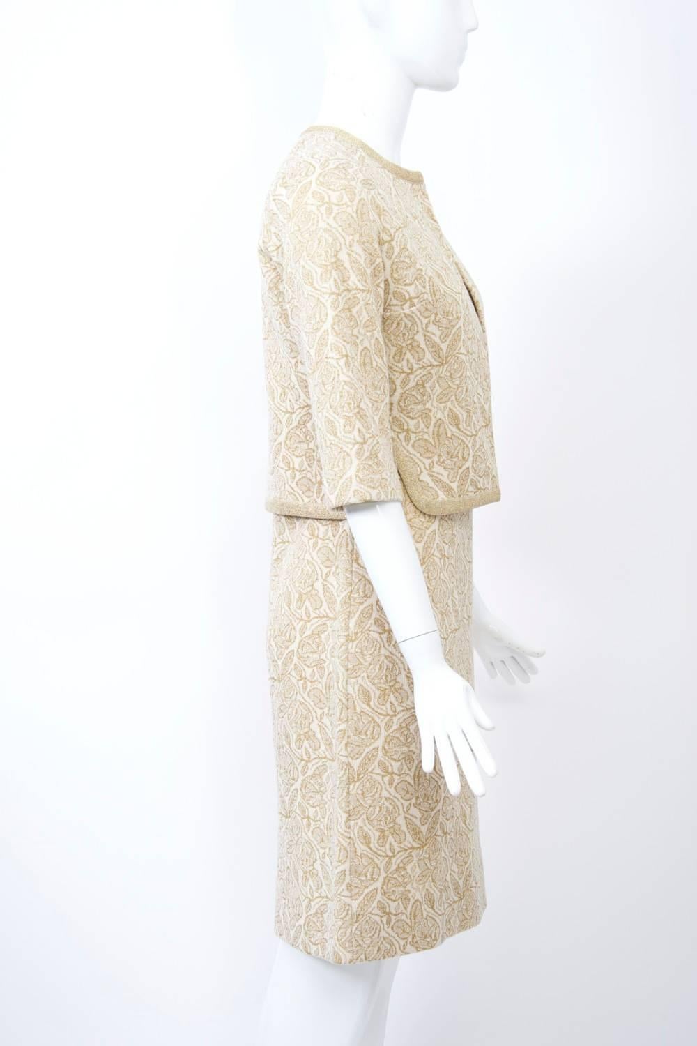 Kimberly was one of the best knitwear manufacturers in mid-century America. This ensemble, from the 1960s, consists of a sheath dress and short, open jacket of ivory ground with gold metallic weave in an abstract leaf pattern. The body hugging dress